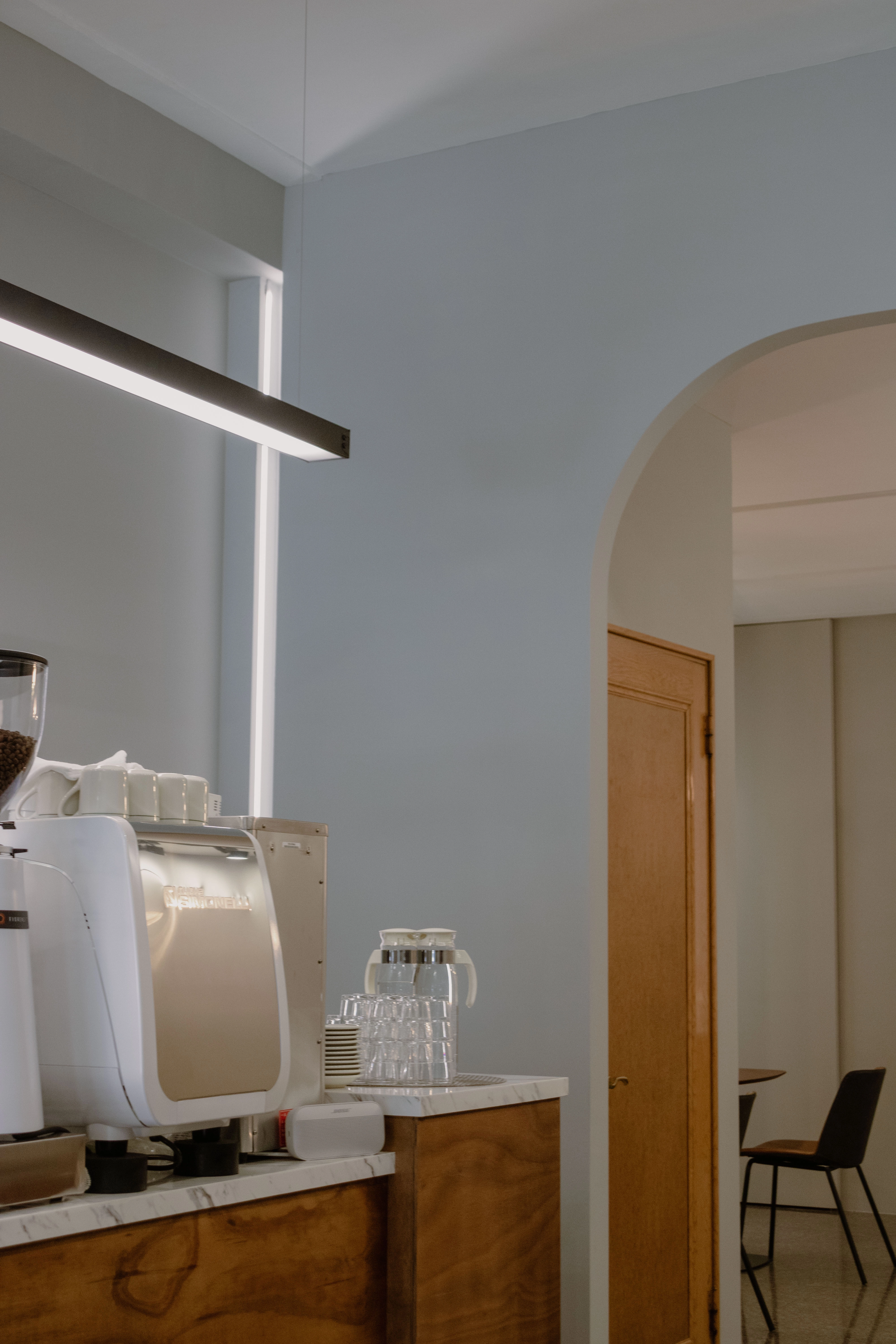 德盈設計規劃：天花板與櫃體運用內崁燈條增加照明，柔和光線勾勒層次，提升咖啡廳空間精緻感。