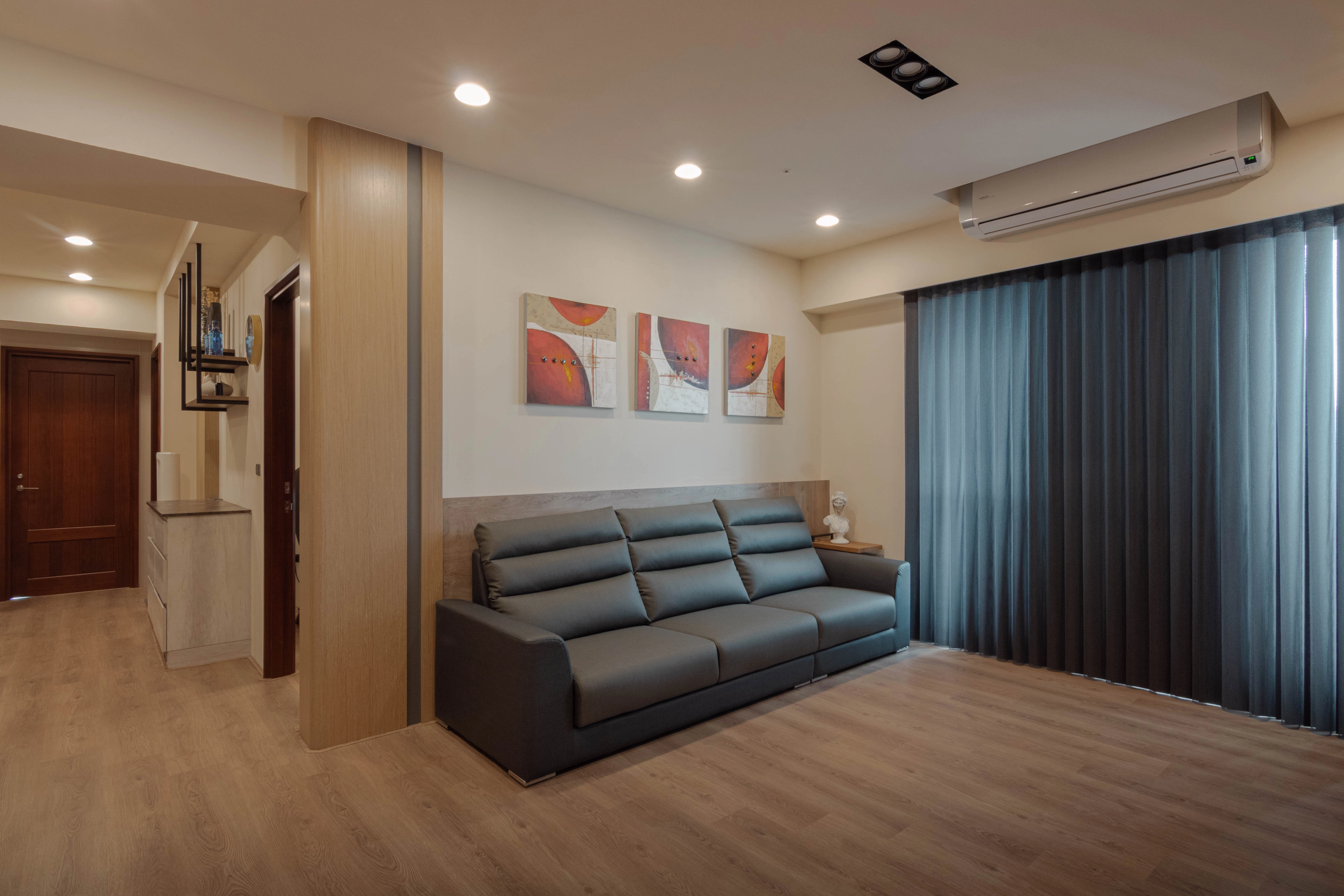 德盈客廳案例實景:米色系沙發結合後方半高牆書櫃,兼具收納與視覺通透。