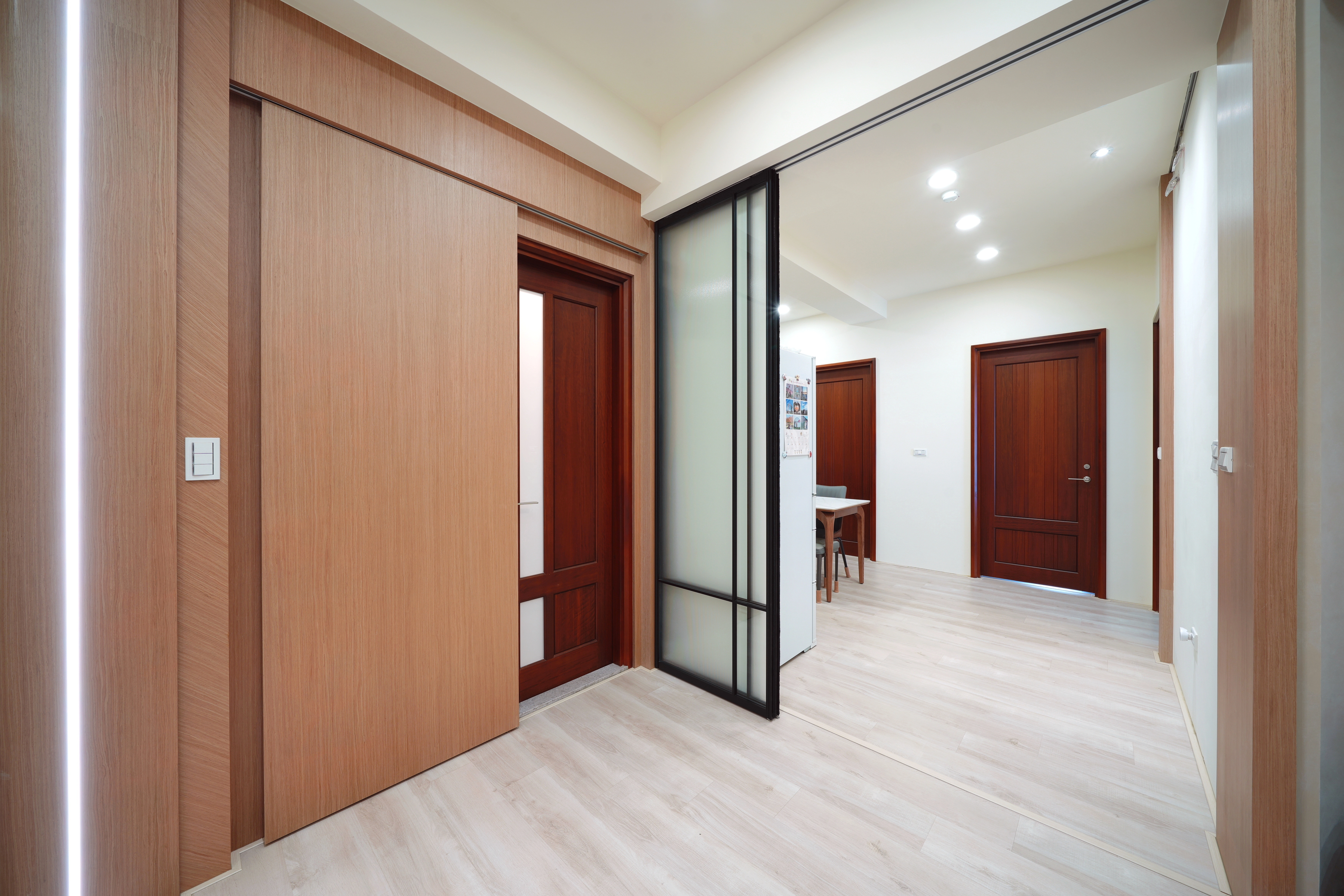 德盈設計隱藏門工程:巧妙收納廁所入口,搭配穿透感推拉門優化餐廳動線與採光。