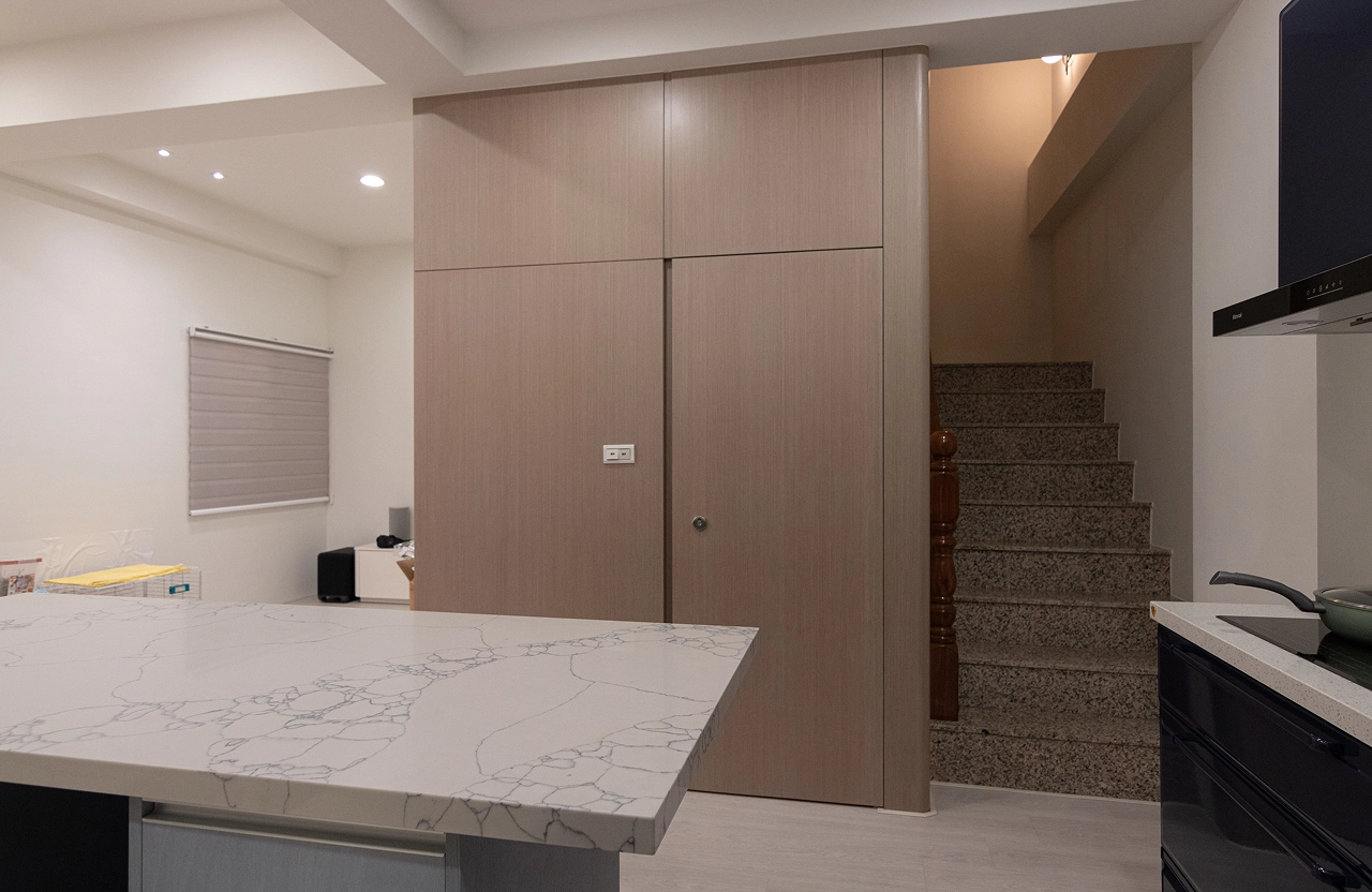 德盈室內設計：運用木質壁板打造隱藏門，巧妙修飾廁所入口並整合樓梯牆面，提升居家視覺簡約感。