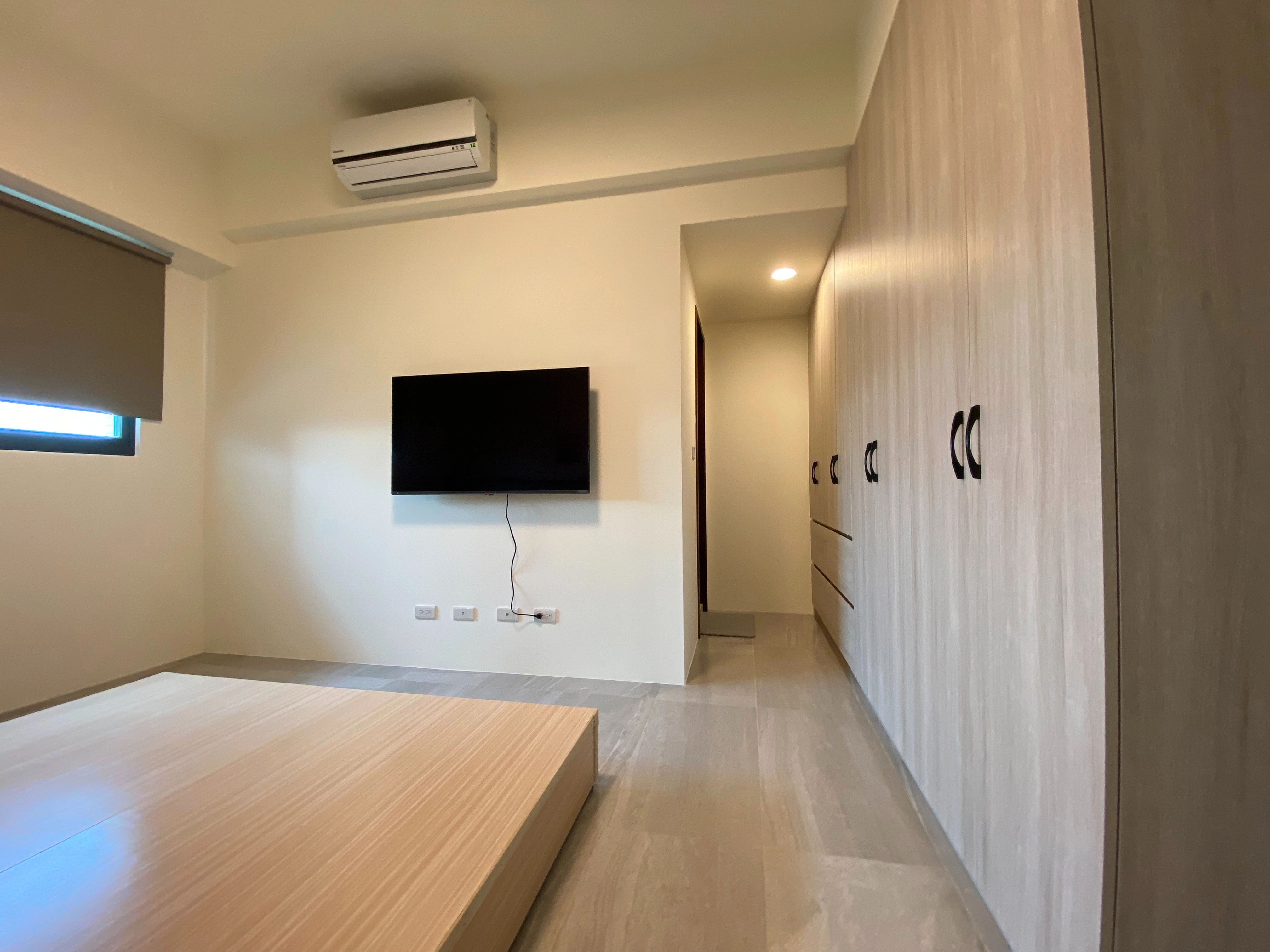 德盈設計:客製化木紋系統衣櫃,將高效收納機能與溫馨質感完美結合,提升主臥室的美感層次。