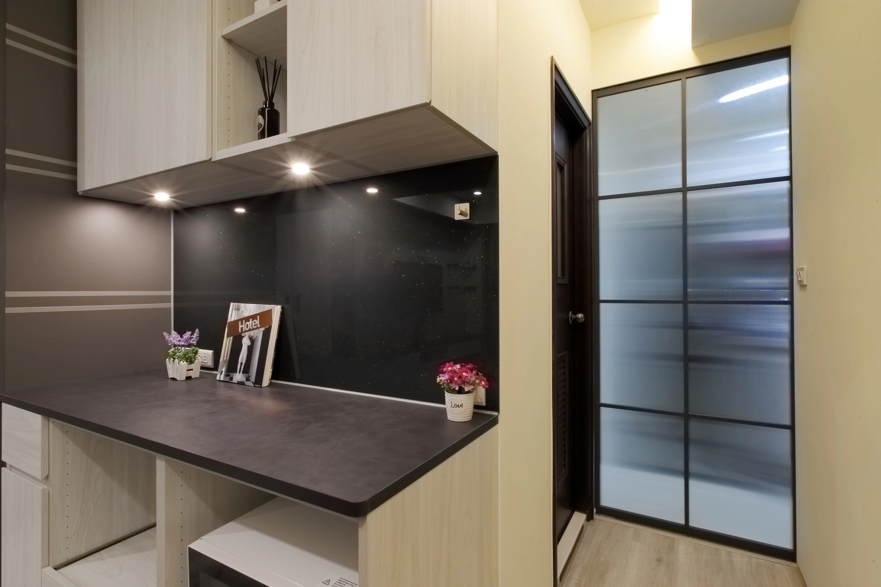 德盈設計餐廚實景:多功能電器櫃配置微波爐收納位,搭配黑玻背板更顯質感。