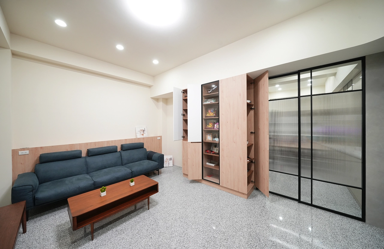 沙發背牆與大型系統收納櫃結合，運用裝修預算打造高質感客廳空間