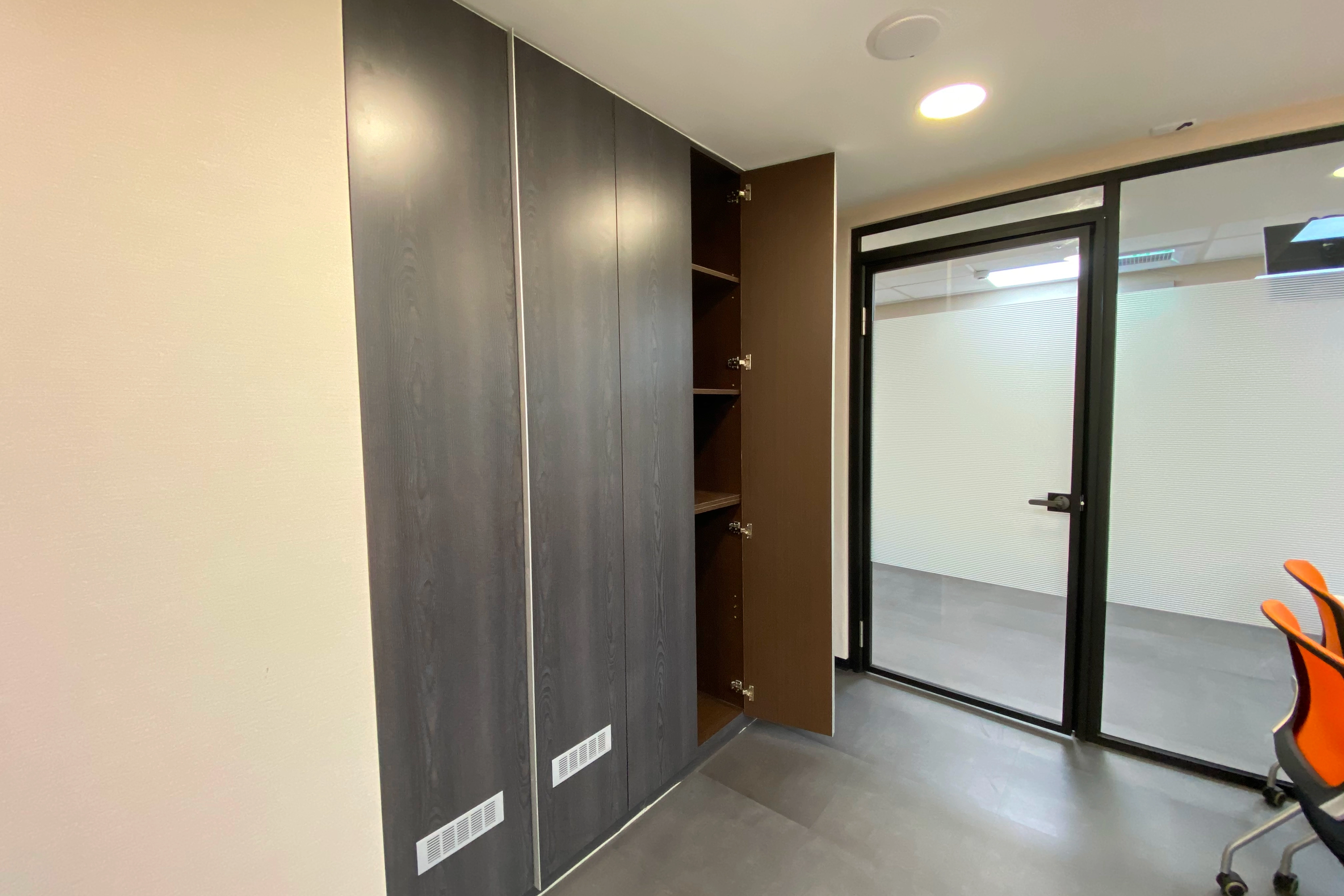 系統櫃提供完善儲物: 沿牆設大量木紋收納櫃,確保用品妥善歸位,使環境保持整潔。