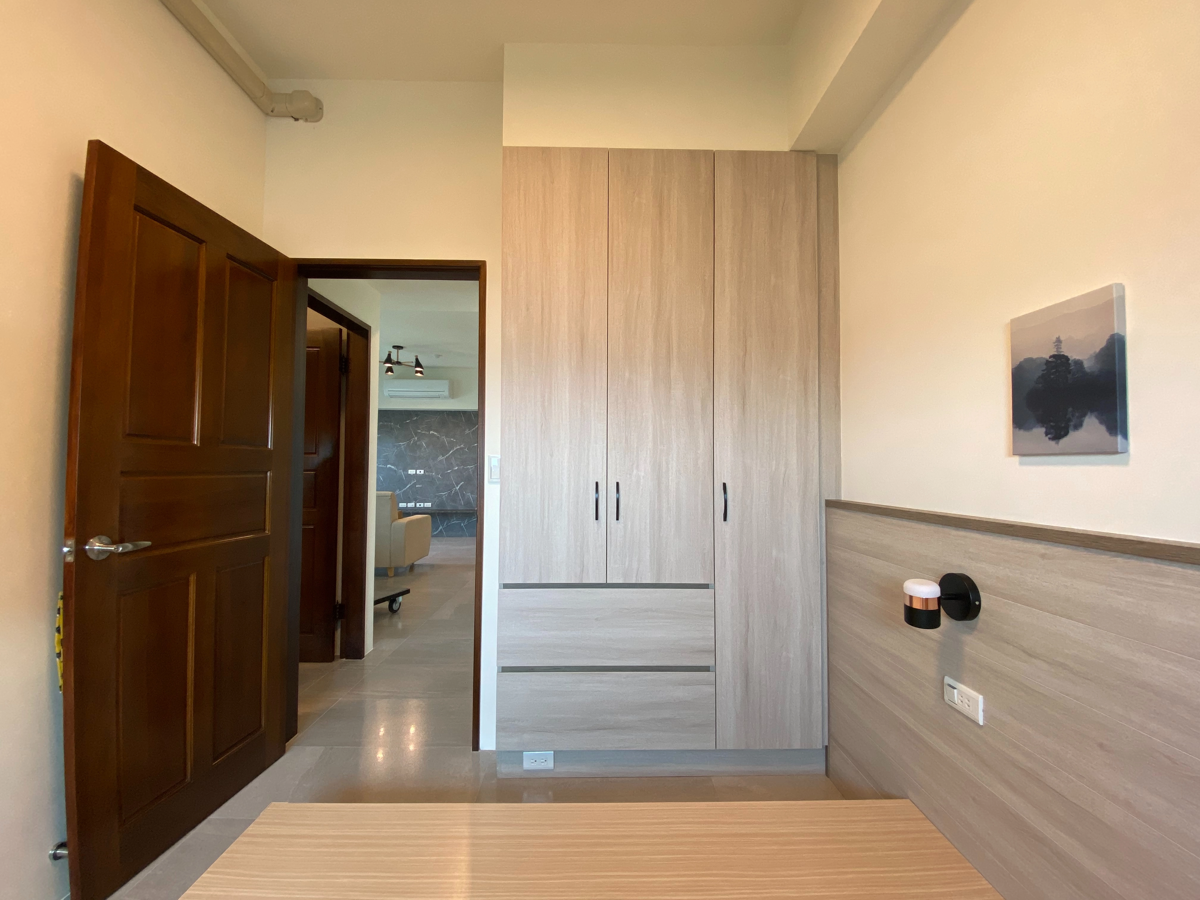 德盈臥室規劃:選用溫潤木紋系統衣櫃搭配黑鐵把手,現代工業風與自然材質的巧妙融合,展現獨特品味。