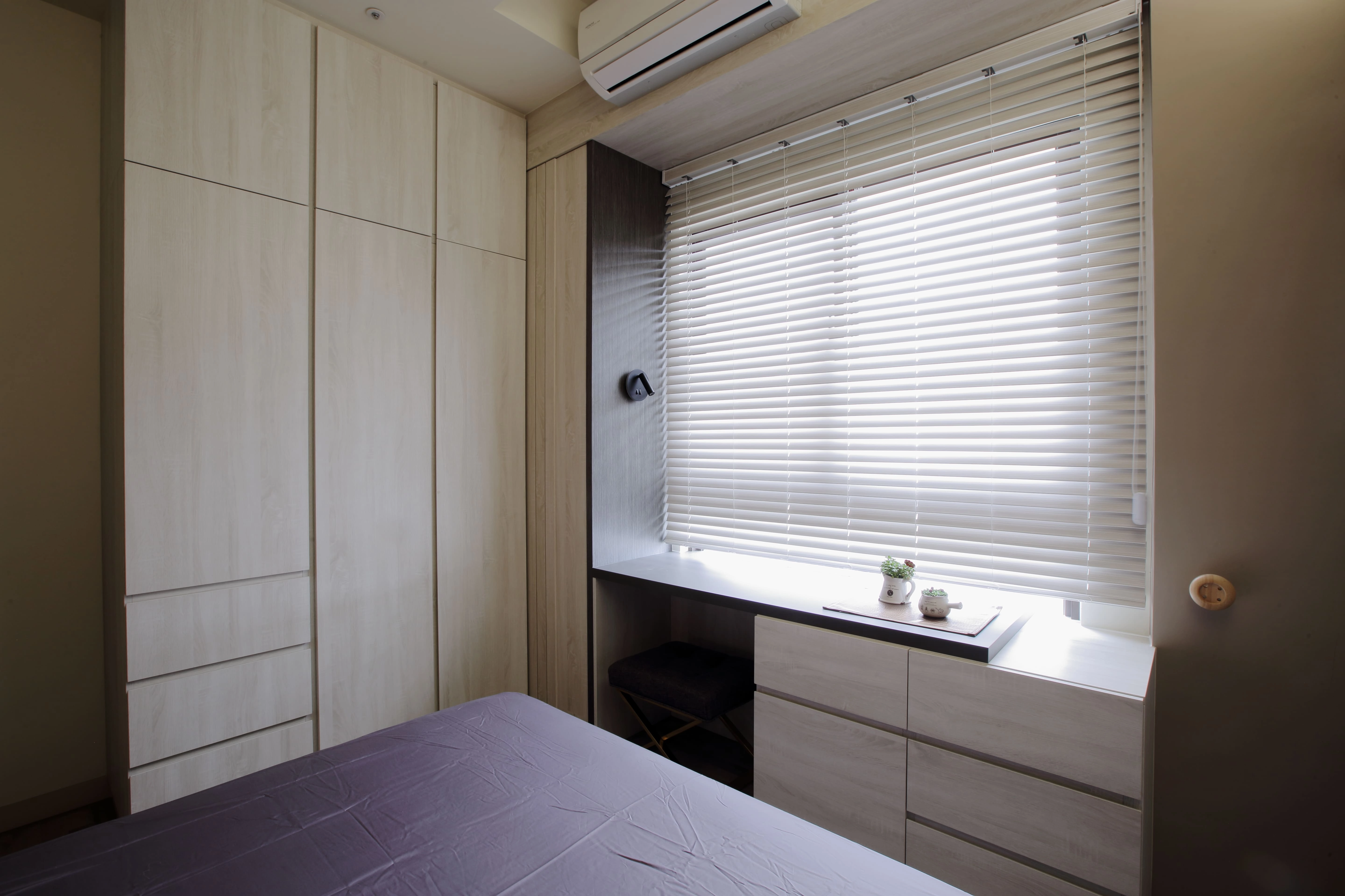 臥室系統家具規劃:頂天立地大容量衣櫃結合窗邊延伸書桌,百葉窗採光設計提升小坪數室內機能。