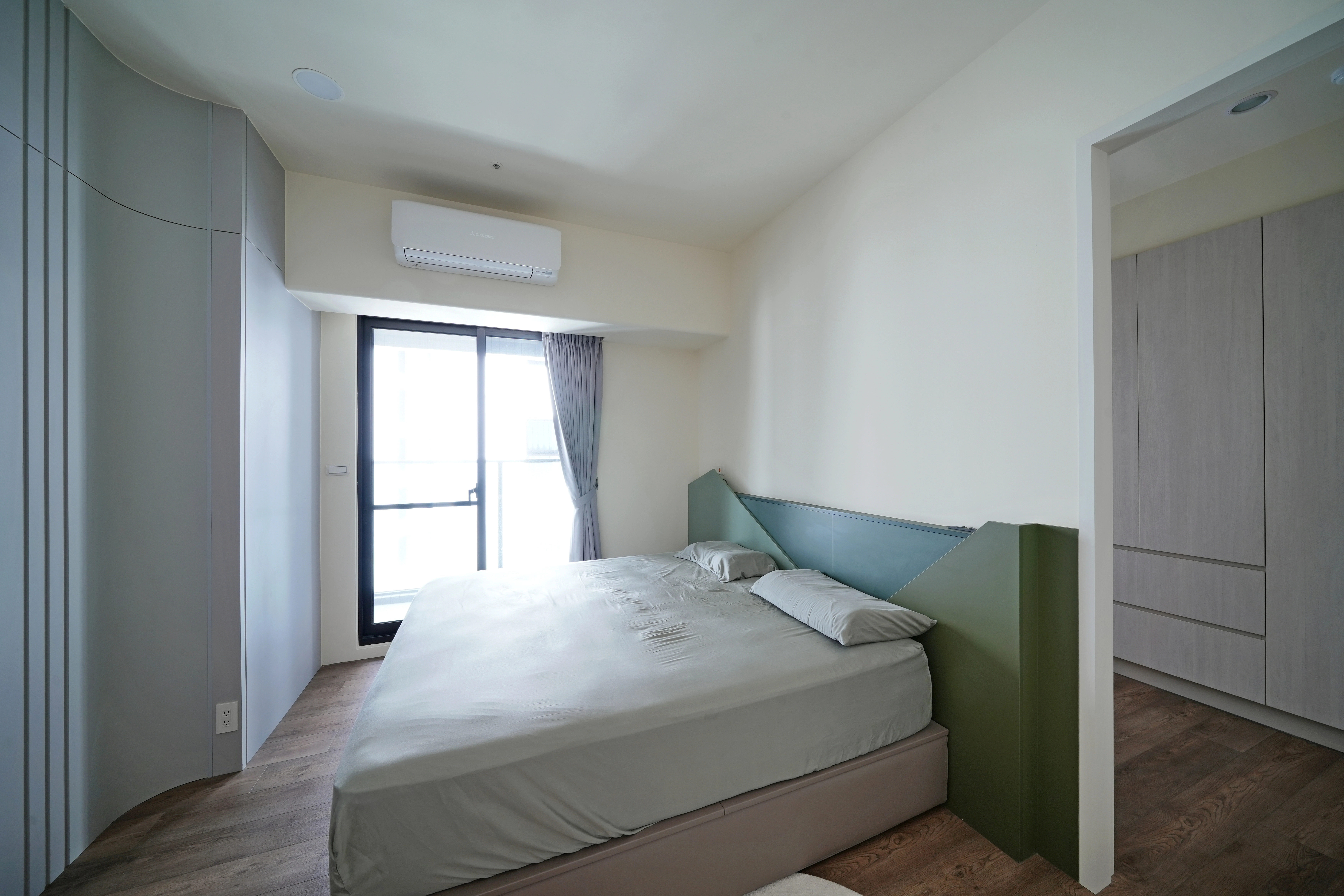 德盈主臥室設計:綠色幾何床頭板點亮空間,流暢動線串聯獨立隔間更衣室。