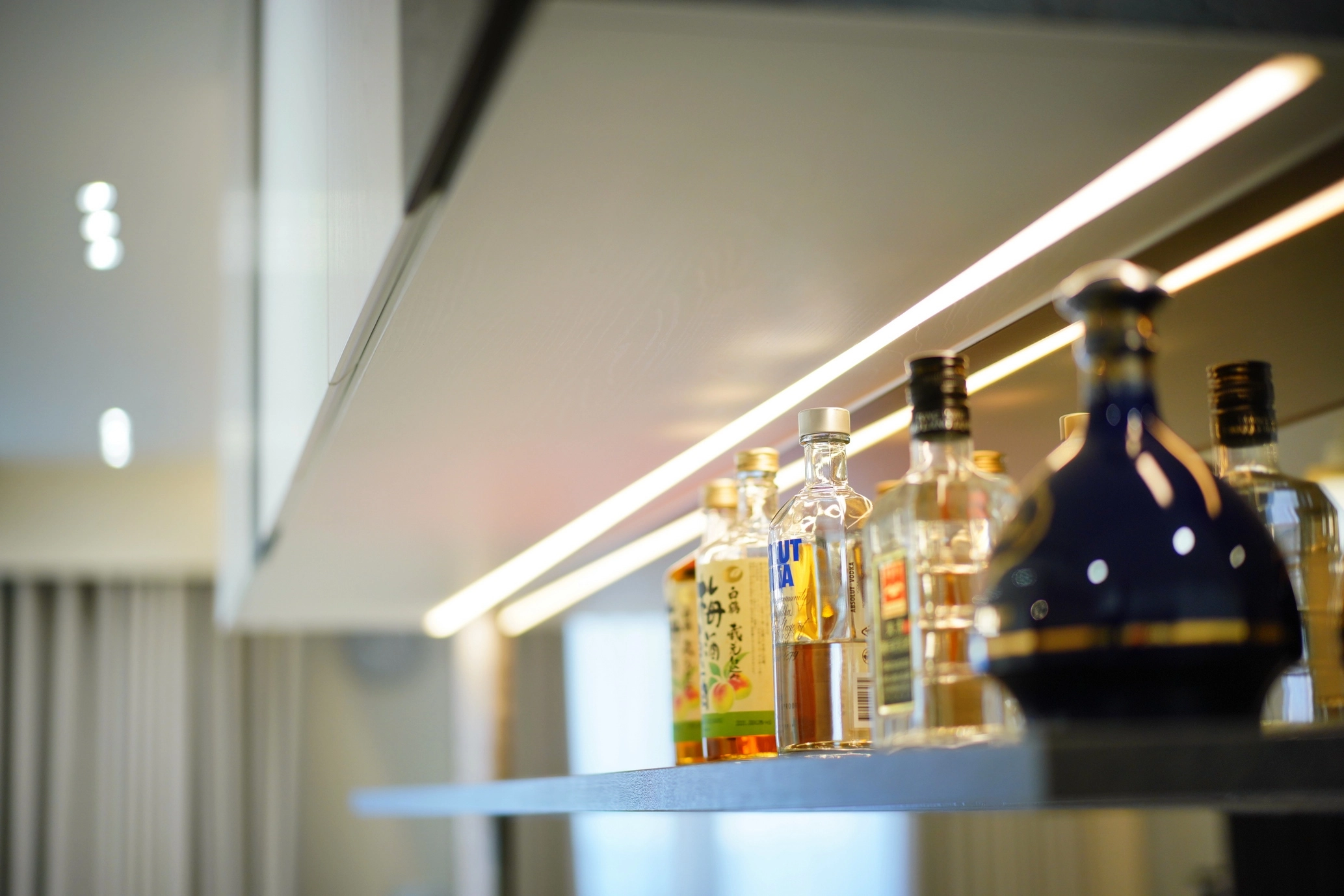 德盈設計餐廚實景:純白系統高櫃結合餐桌配置,打造收納與展示機能兼具的精緻酒櫃區。