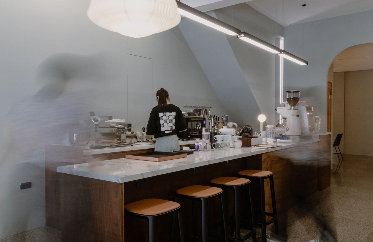 德盈設計咖啡廳商空：質感石紋吧台搭配柔和間接光源，營造極具品味的現代文青風格。