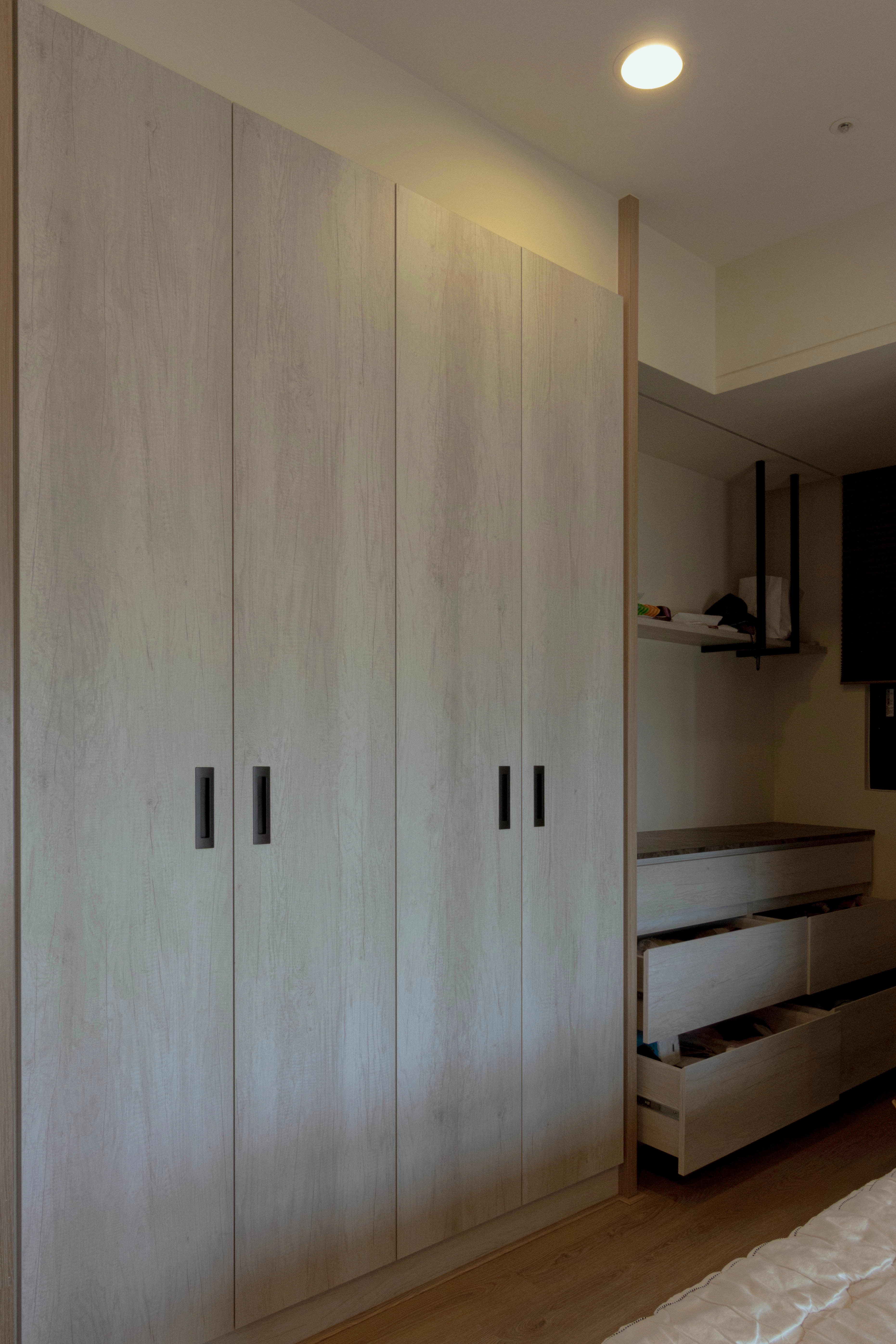 德盈設計臥室實景：現代風對開門系統衣櫃，細緻五金與俐落門板提升收納質感。