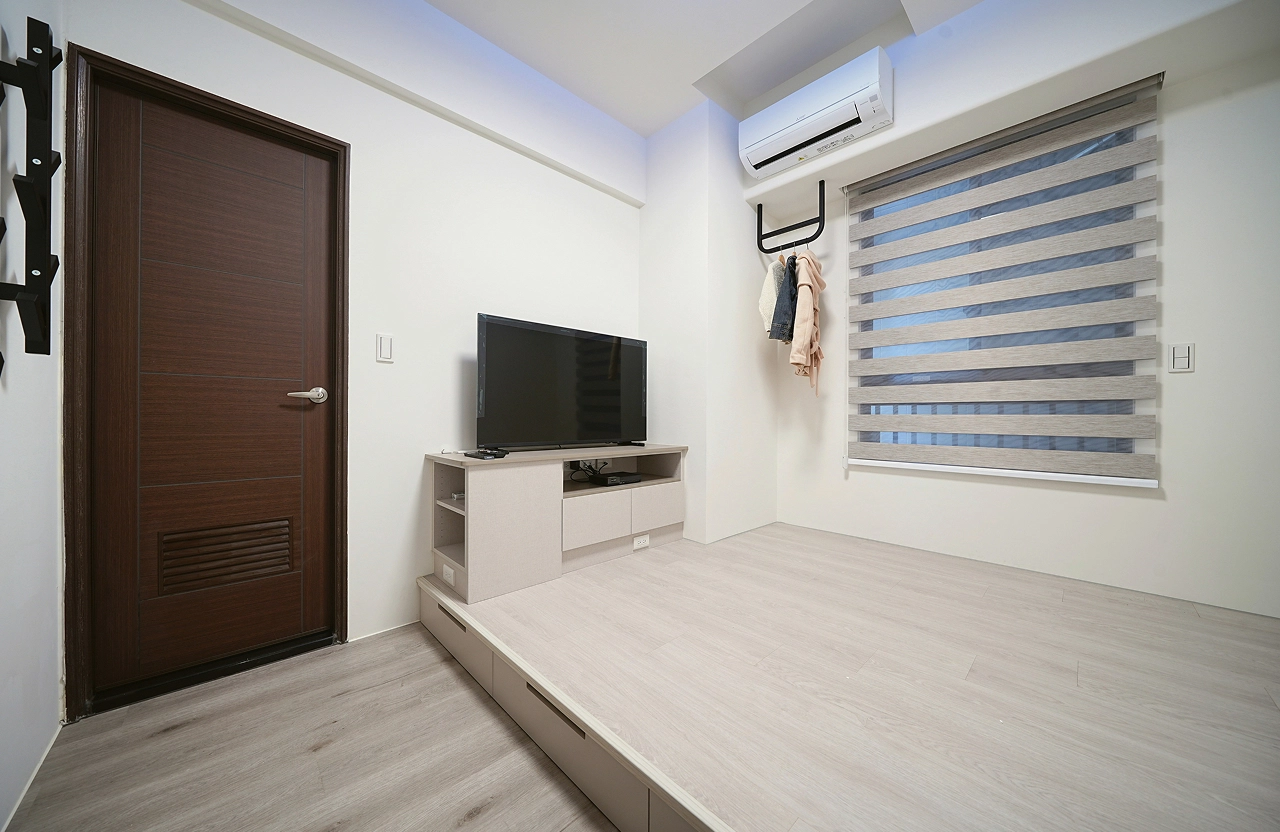 德盈室內設計：臥室架高地板設計，結合客製化電視收納櫃與黑鐵吊衣架，極大化小坪數居家儲物空間。