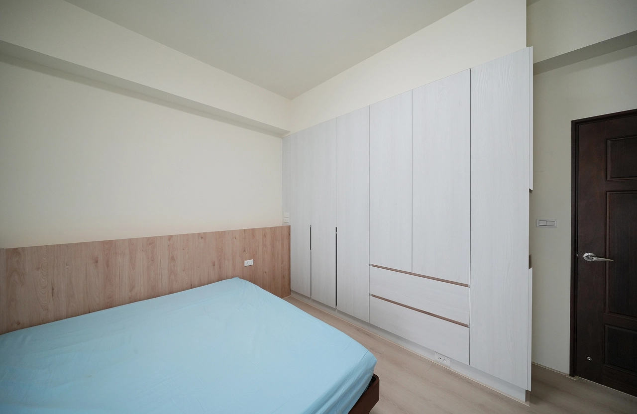 主臥暖木床頭背牆，超耐磨木地板。整面開門衣櫃，轉向櫃極大化儲物機能。