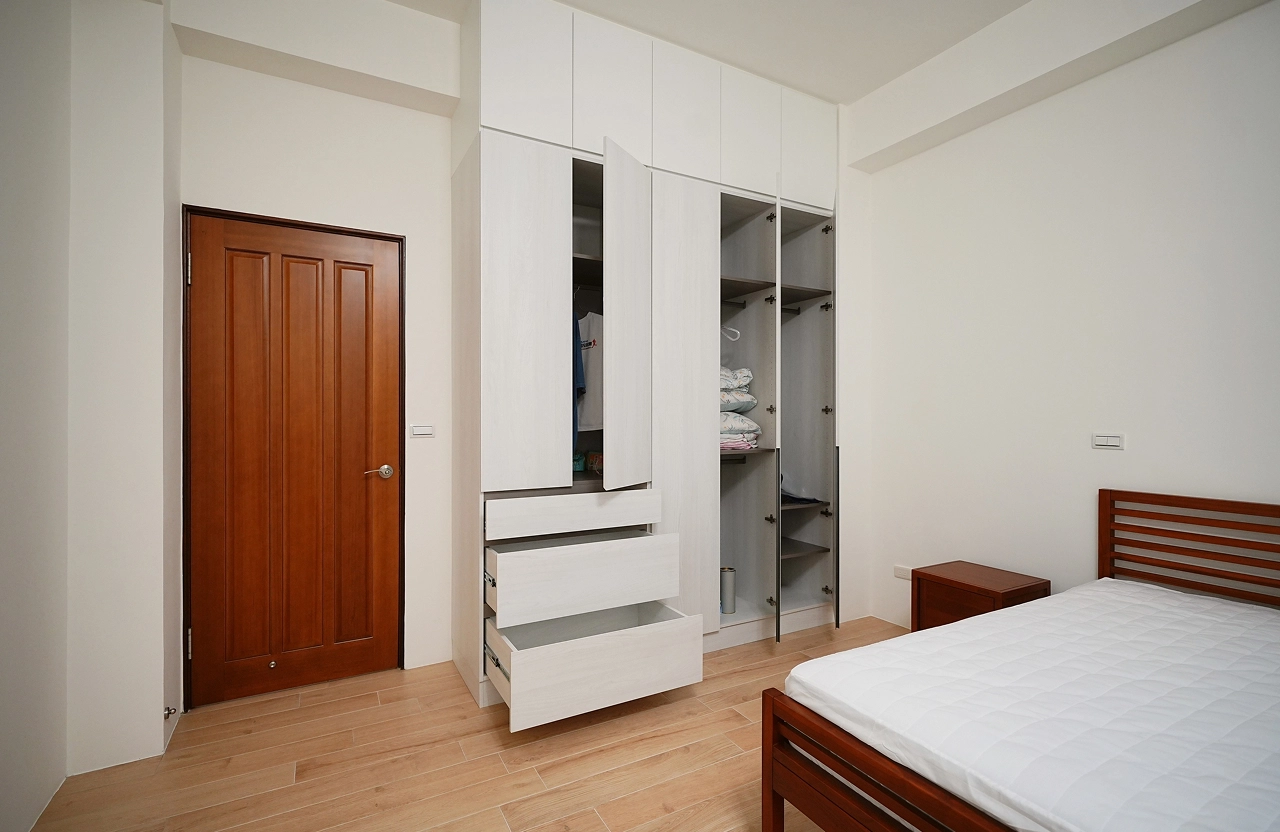 德盈空間規劃：系統櫃選用霧面質感材質，與暖色木地板相互呼應，堆疊出沉穩且精緻的臥室美學。