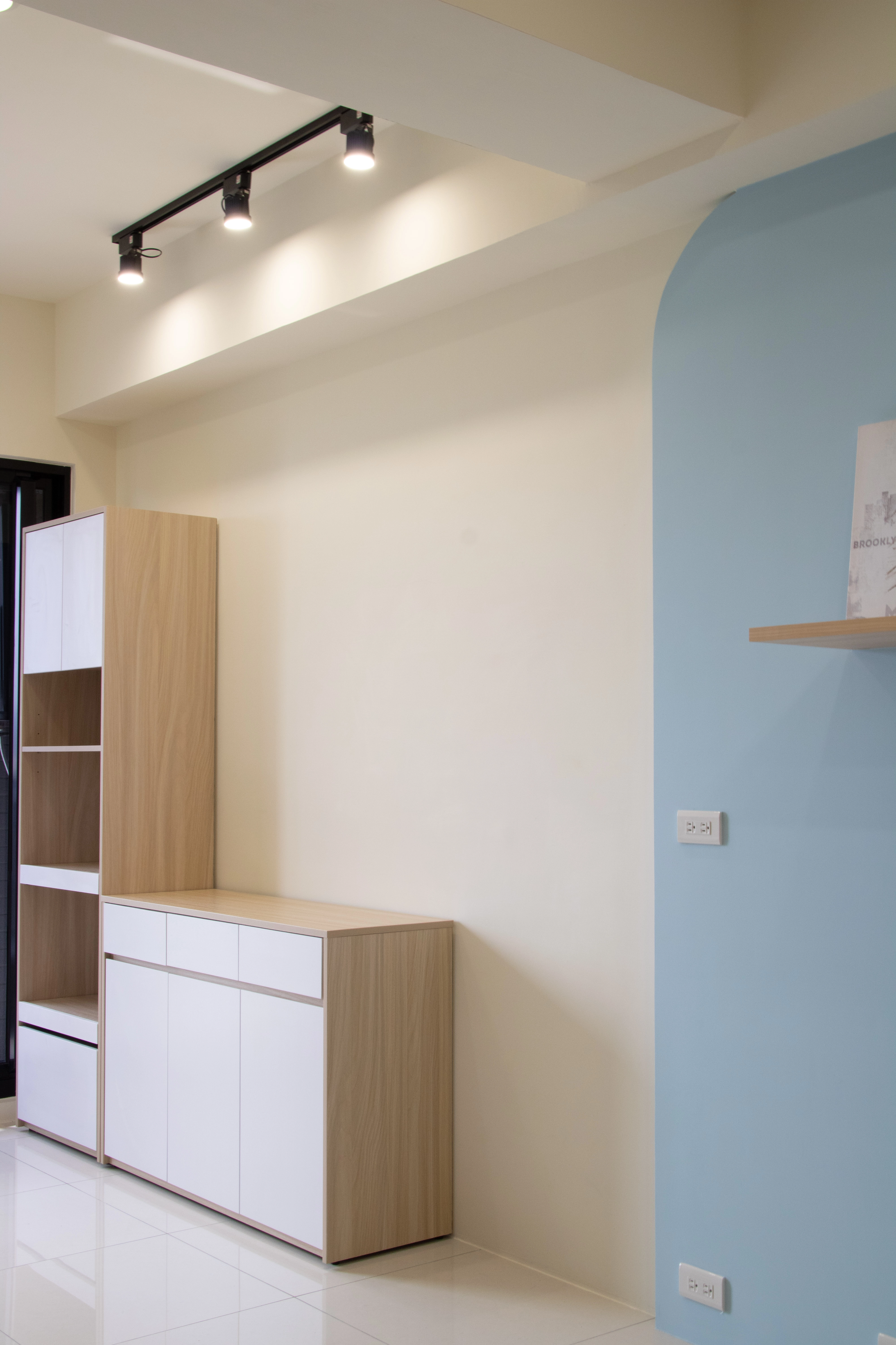 德盈室內設計：客廳選用質感軌道燈搭配柔美圓弧造型天花，透過流暢線條與洗牆光影，營造現代大器居家感。