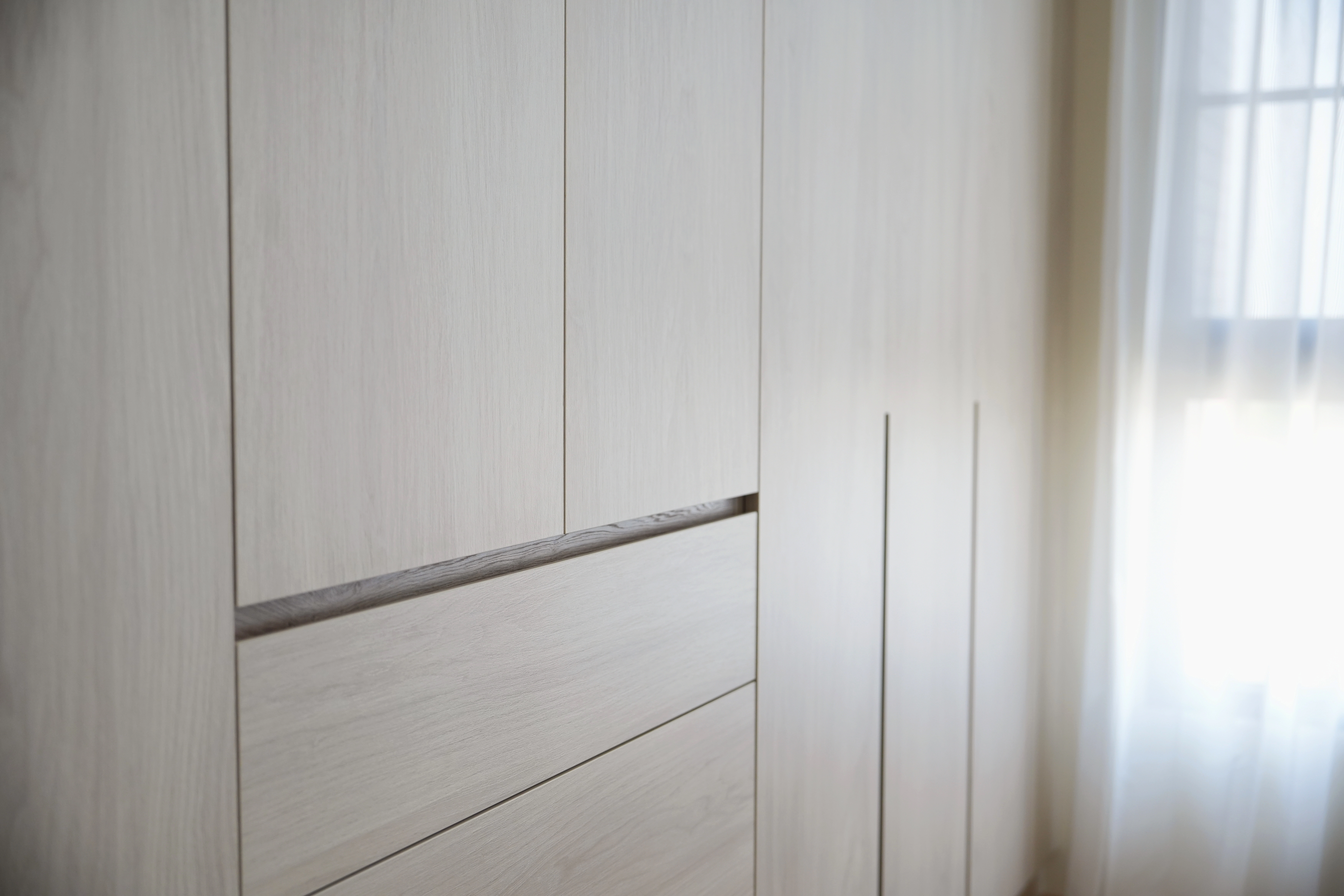 德盈設計系統櫃細節:簡約隱藏式把手設計,極簡線條展現現代工藝美學,提升櫃體整體空間質感。