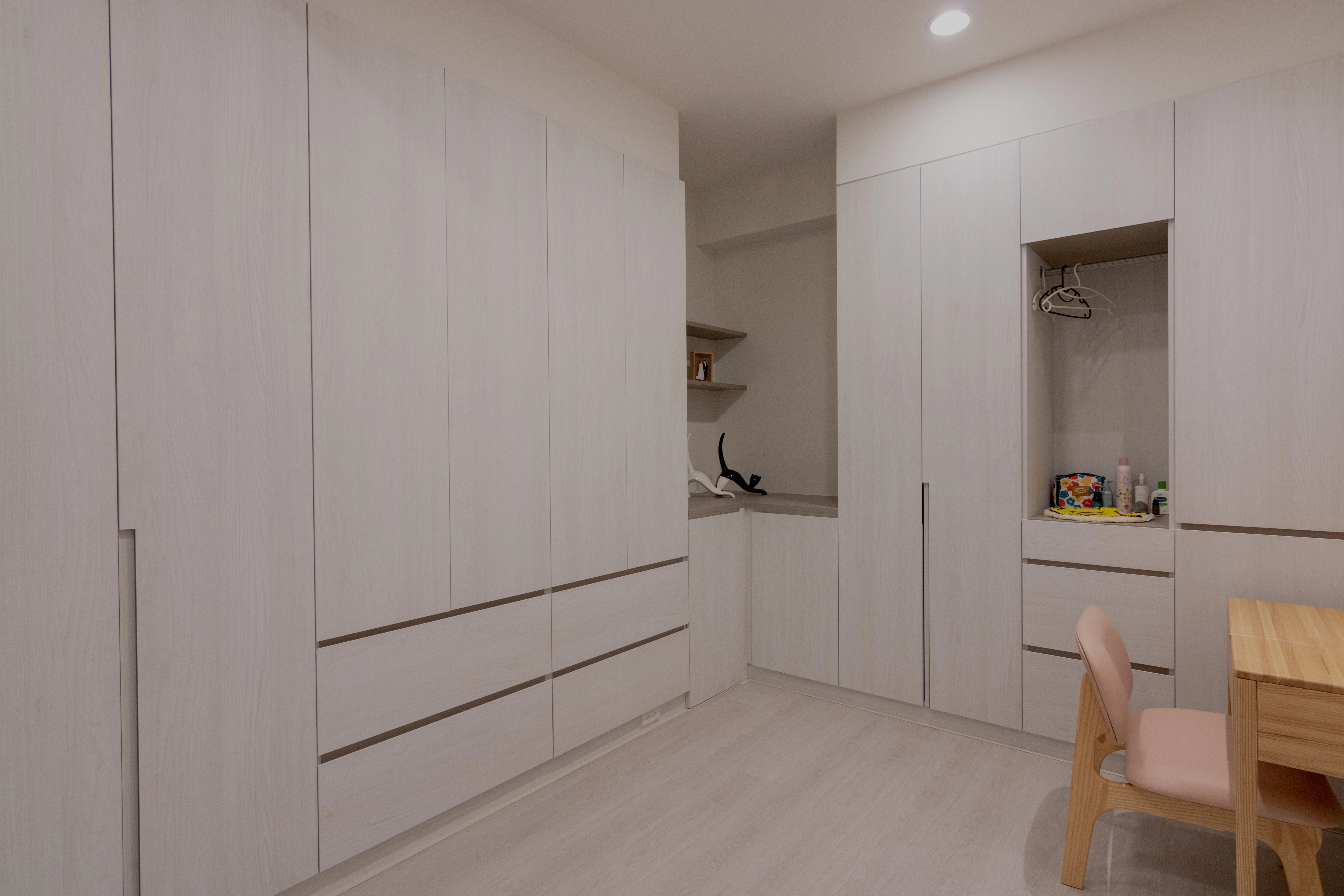 臥室系統家具規劃,白色系統衣櫃連結化妝桌與開放式層板,客製化設計完美滿足日常收納與美妝需求。