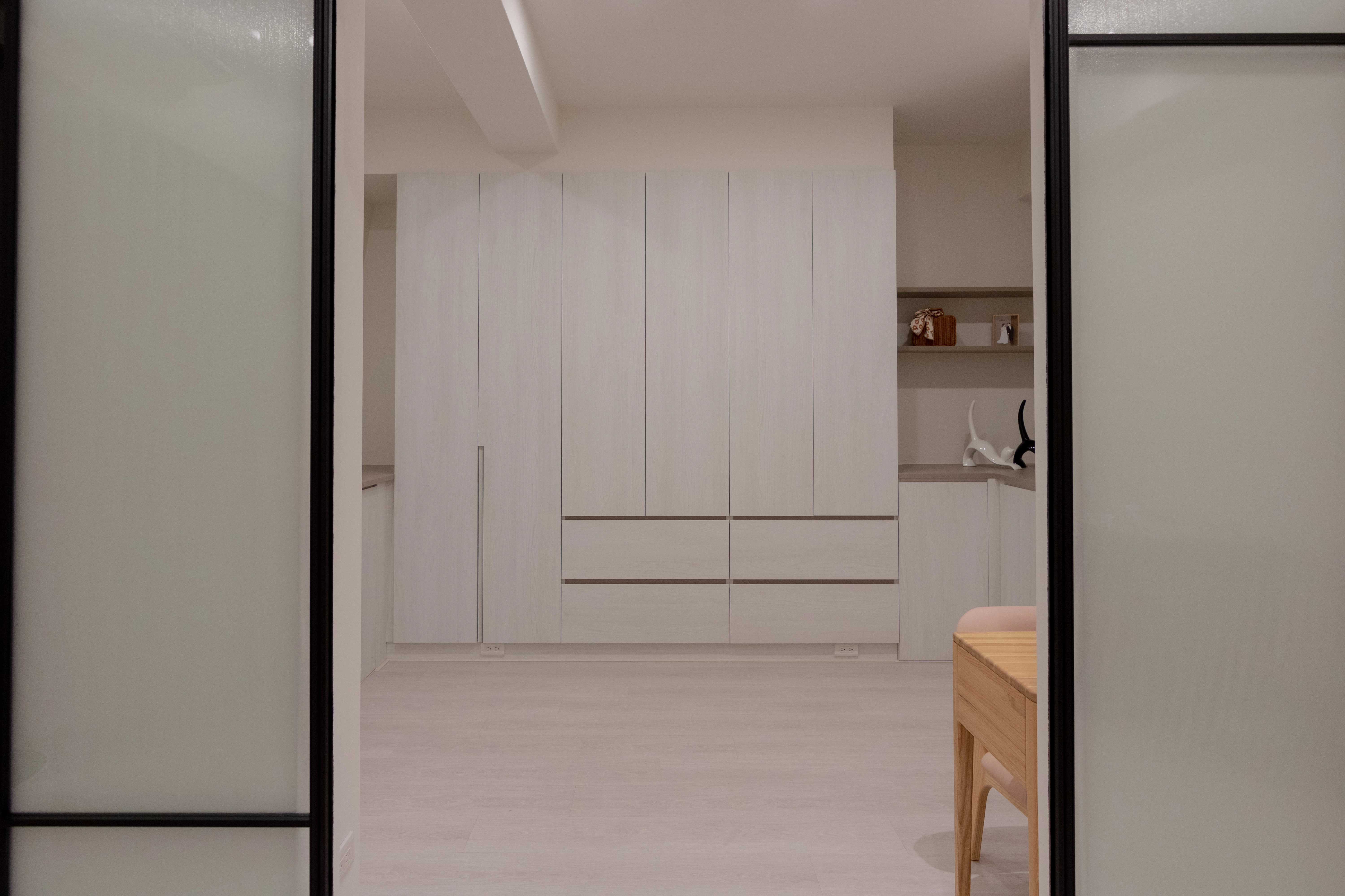 簡約白色木紋系統衣櫃結合現代室內設計,頂天立地設計增加收納空間,營造清爽整潔的居家視覺美感。