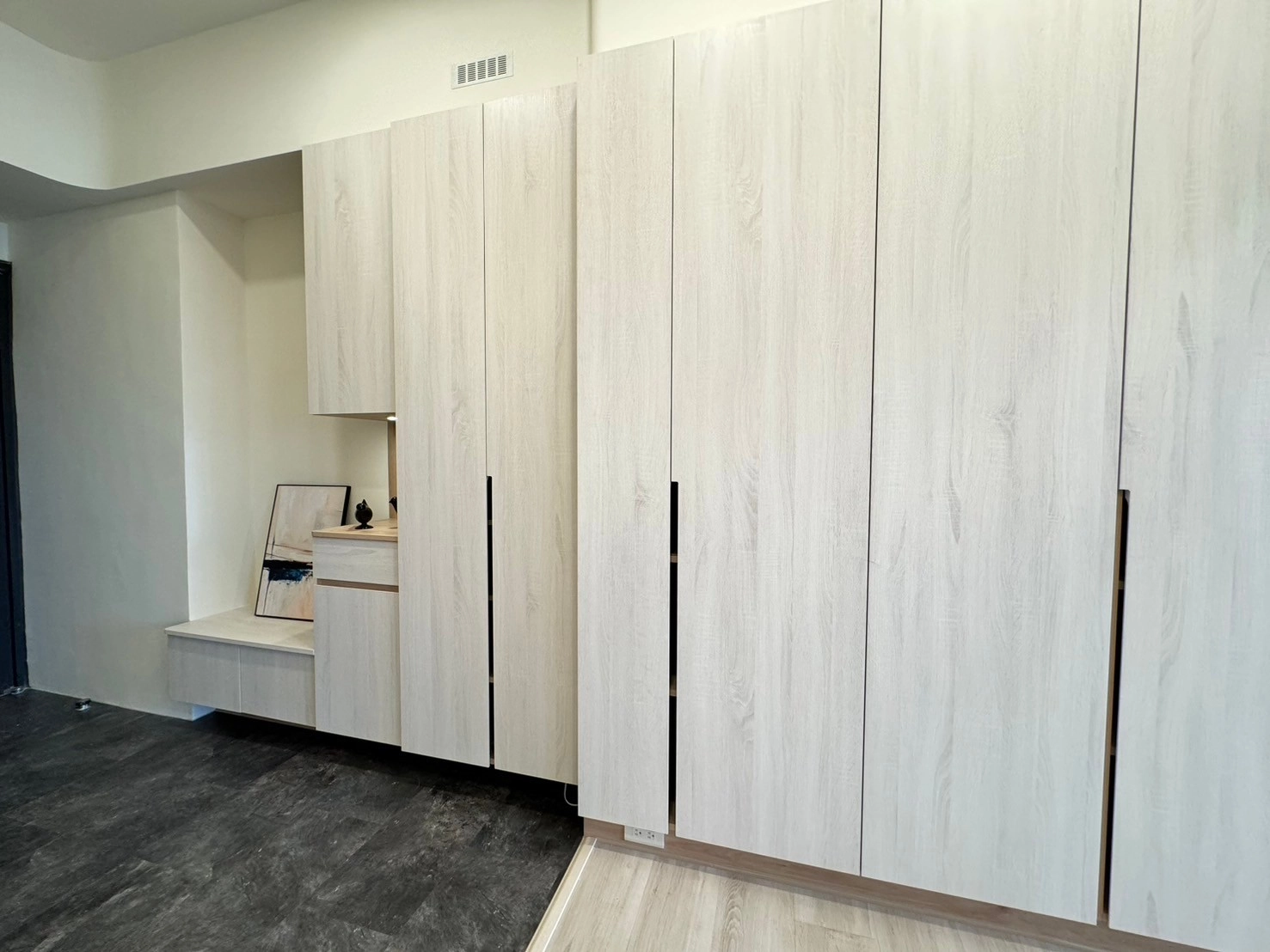 德盈室內設計玄關規劃:採用極簡系統櫃無把手設計,展現俐落線條與現代美感,讓空間視覺更平整。