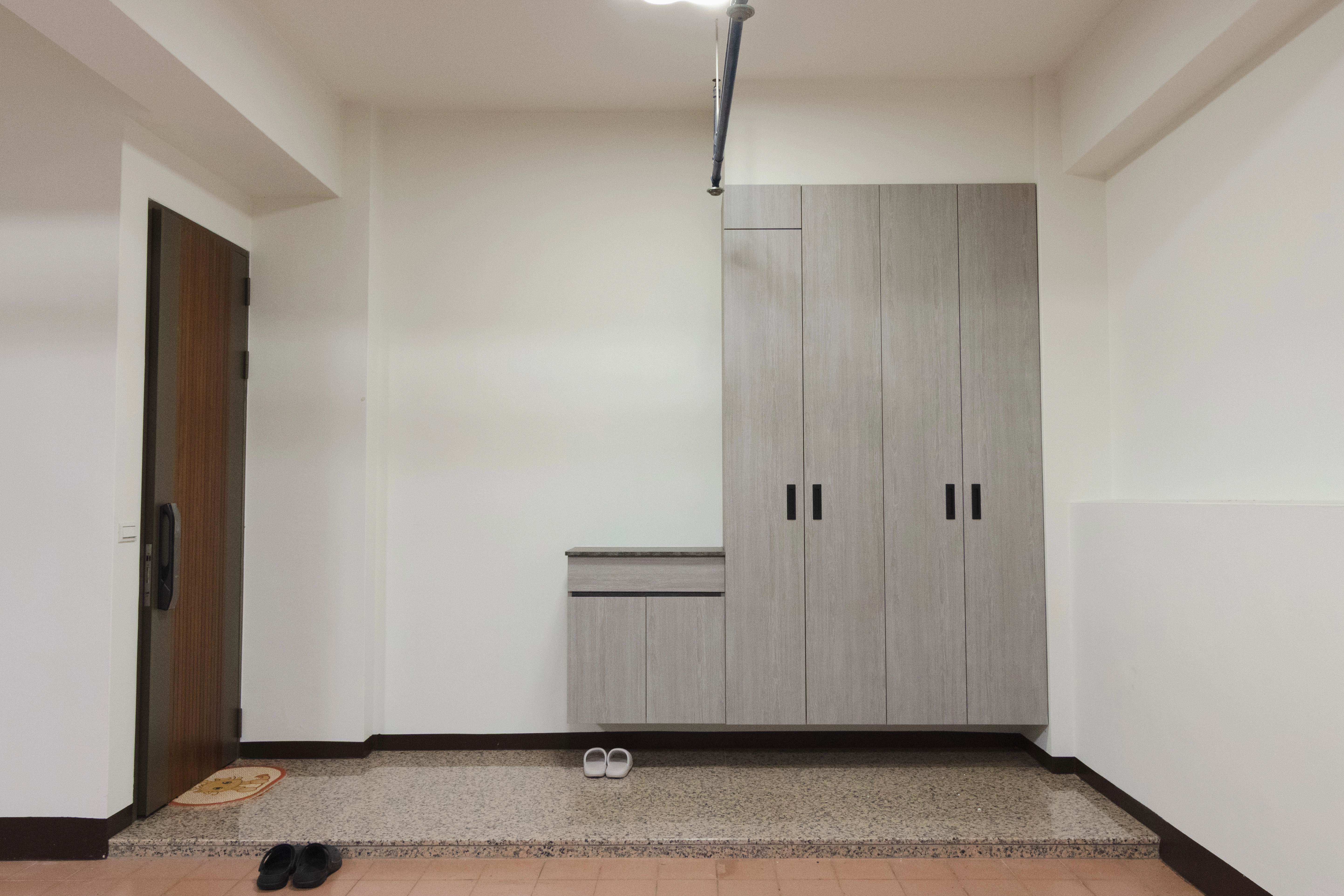 透天車庫空間優化,安裝懸空式系統鞋櫃,讓鞋櫃底下也能輕鬆打掃,提供大容量收納同時營造明亮整潔的門口意象。