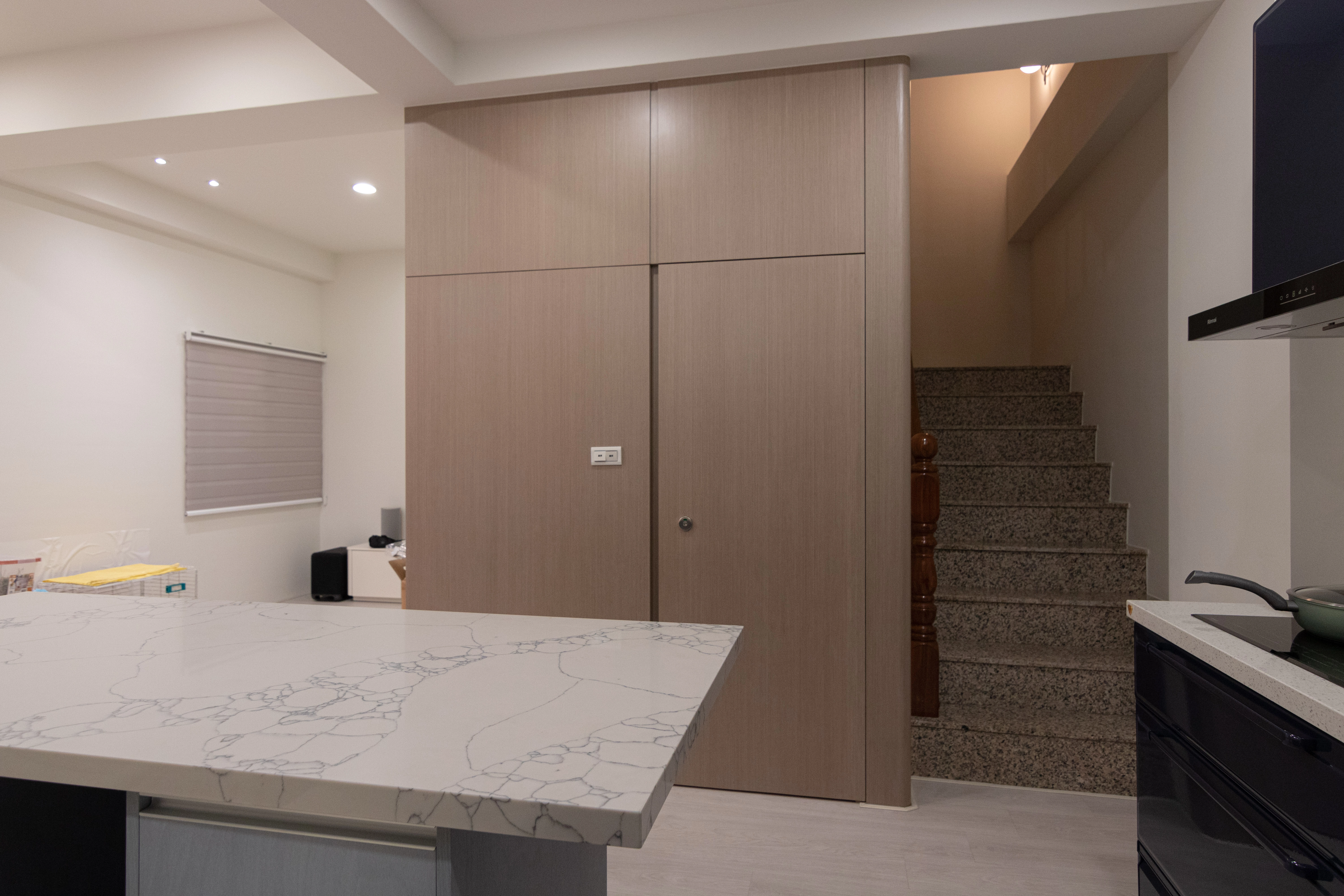 德盈室內設計:運用木質壁板打造隱藏門,巧妙修飾廁所入口並整合樓梯牆面,提升居家視覺簡約感。