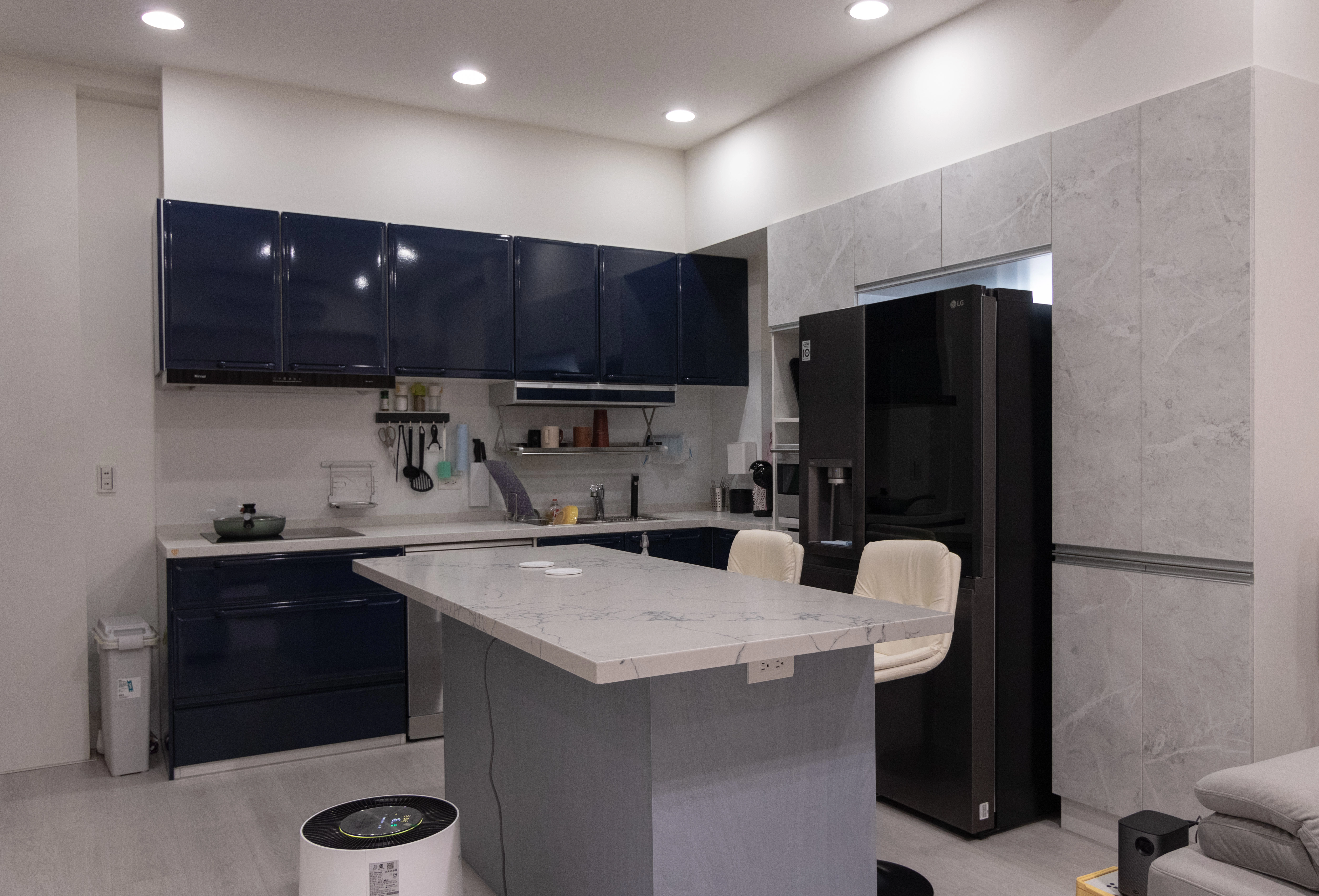 德盈廚房設計:中古屋翻新選用深藍亮面櫥櫃,內嵌式冰箱與中島插座規劃,極大化餐廚空間收納機能。