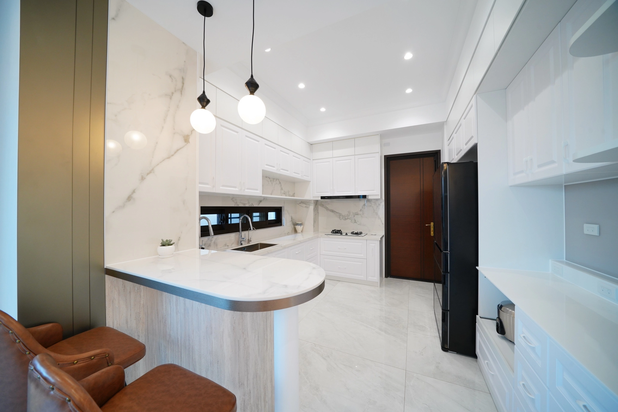 開放式廚房規劃中島與客製化電器櫃,將實用機能完美隱藏於美學。