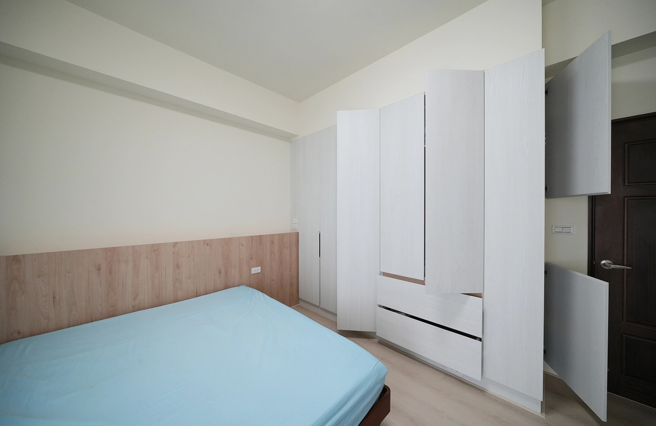 新成屋透天主臥規劃整牆系統衣櫃，木質床頭板營造溫暖氛圍