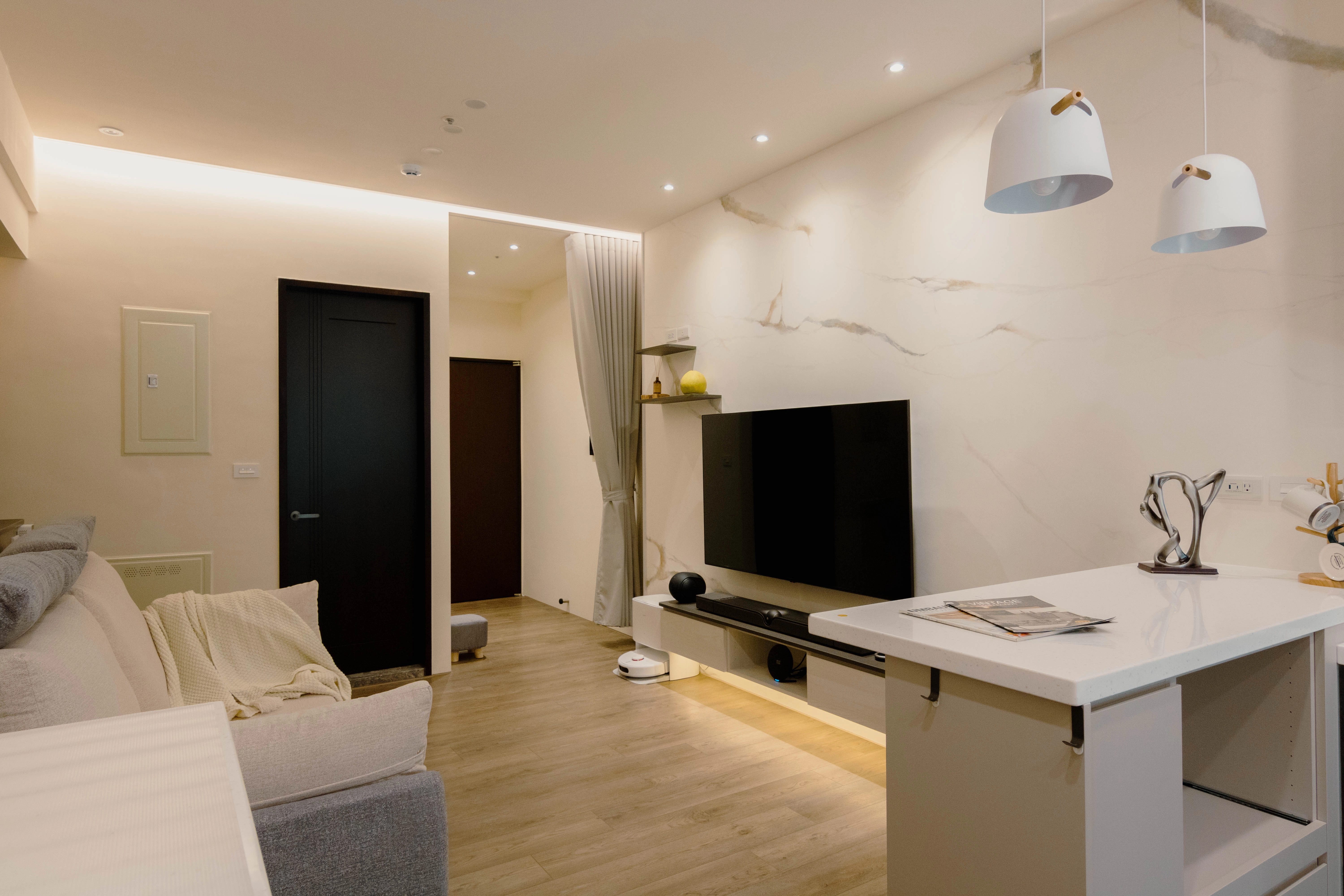 德盈專業規劃：電視牆整合藝術層板與掃地機基地，打造美感兼具的收納空間。