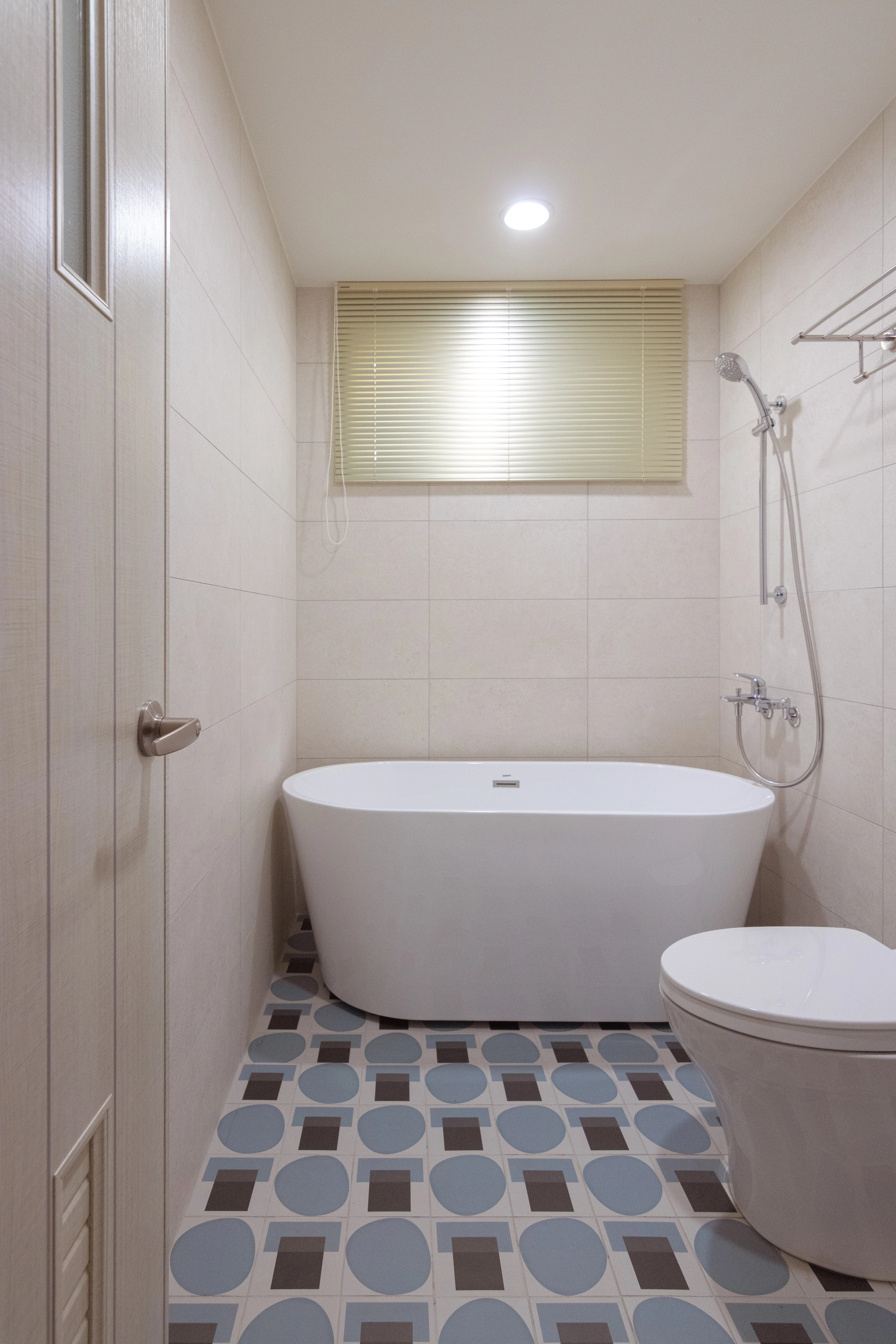 現代衛浴空間規劃，白色懸掛式洗手台搭配復古幾何花磚地磚，完美結合實用機能與獨特室內設計風格。