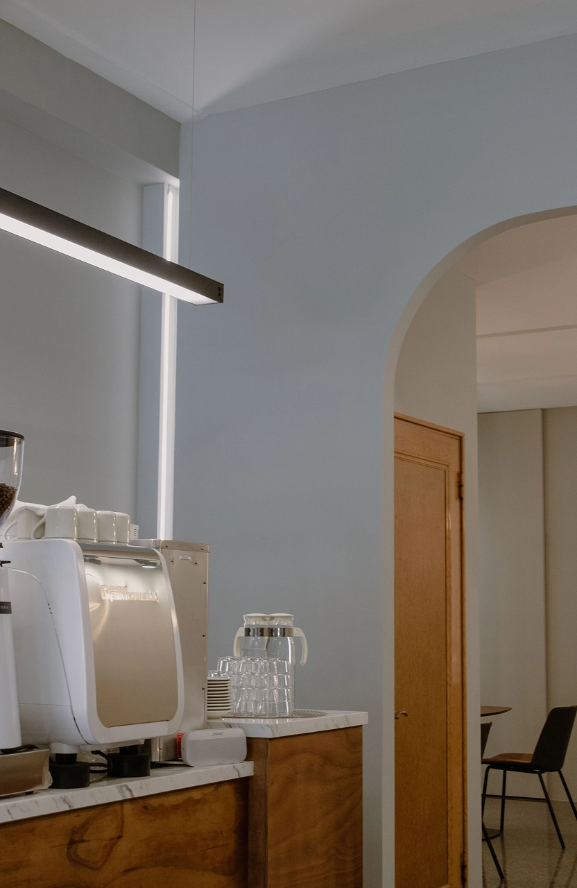 德盈設計規劃：天花板與櫃體運用內崁燈條增加照明，柔和光線勾勒層次，提升咖啡廳空間精緻感。