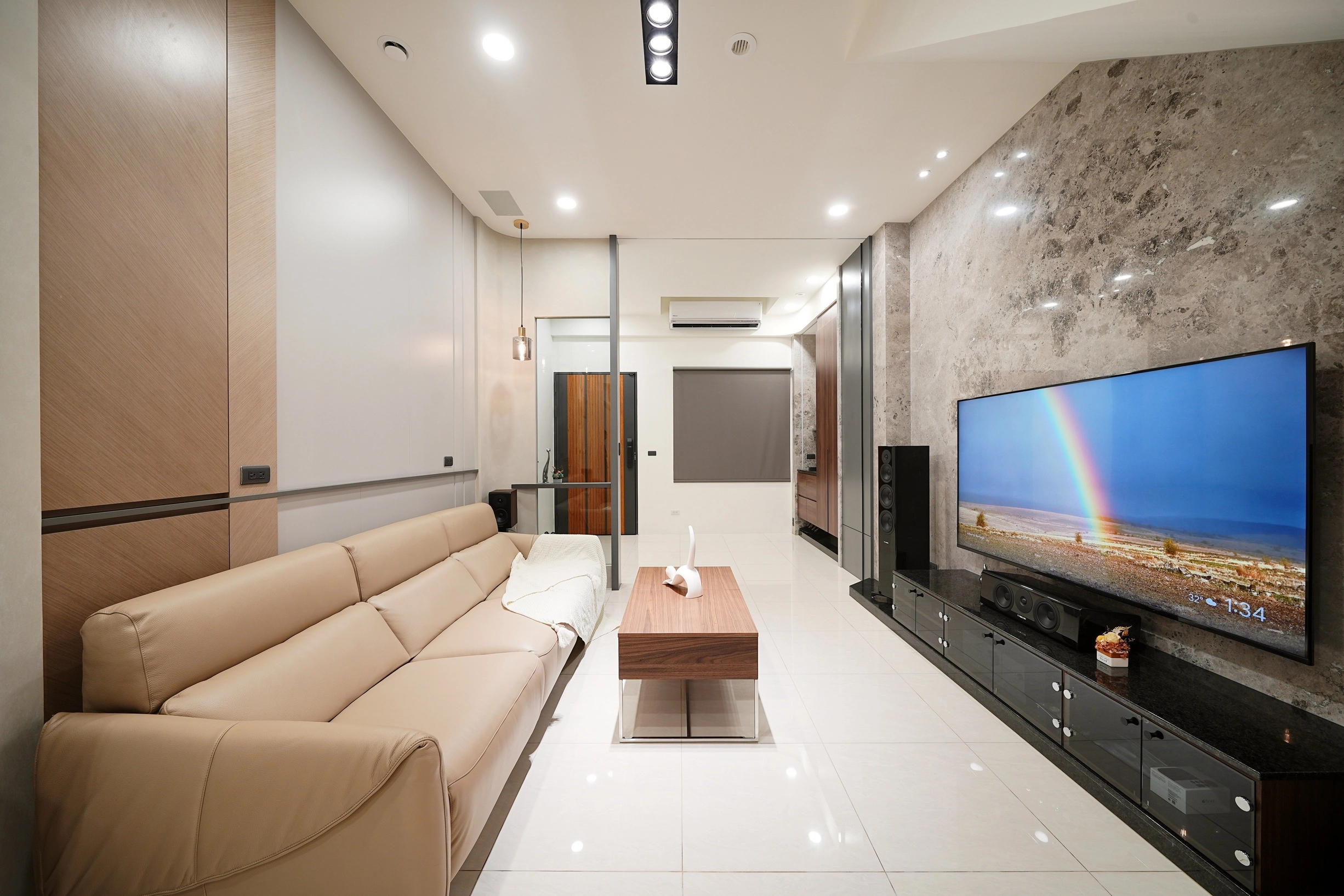 德盈空間規劃:選用天然紋理大理石電視牆,結合隱藏式收納櫃,呈現低調奢華的客廳視覺重點。