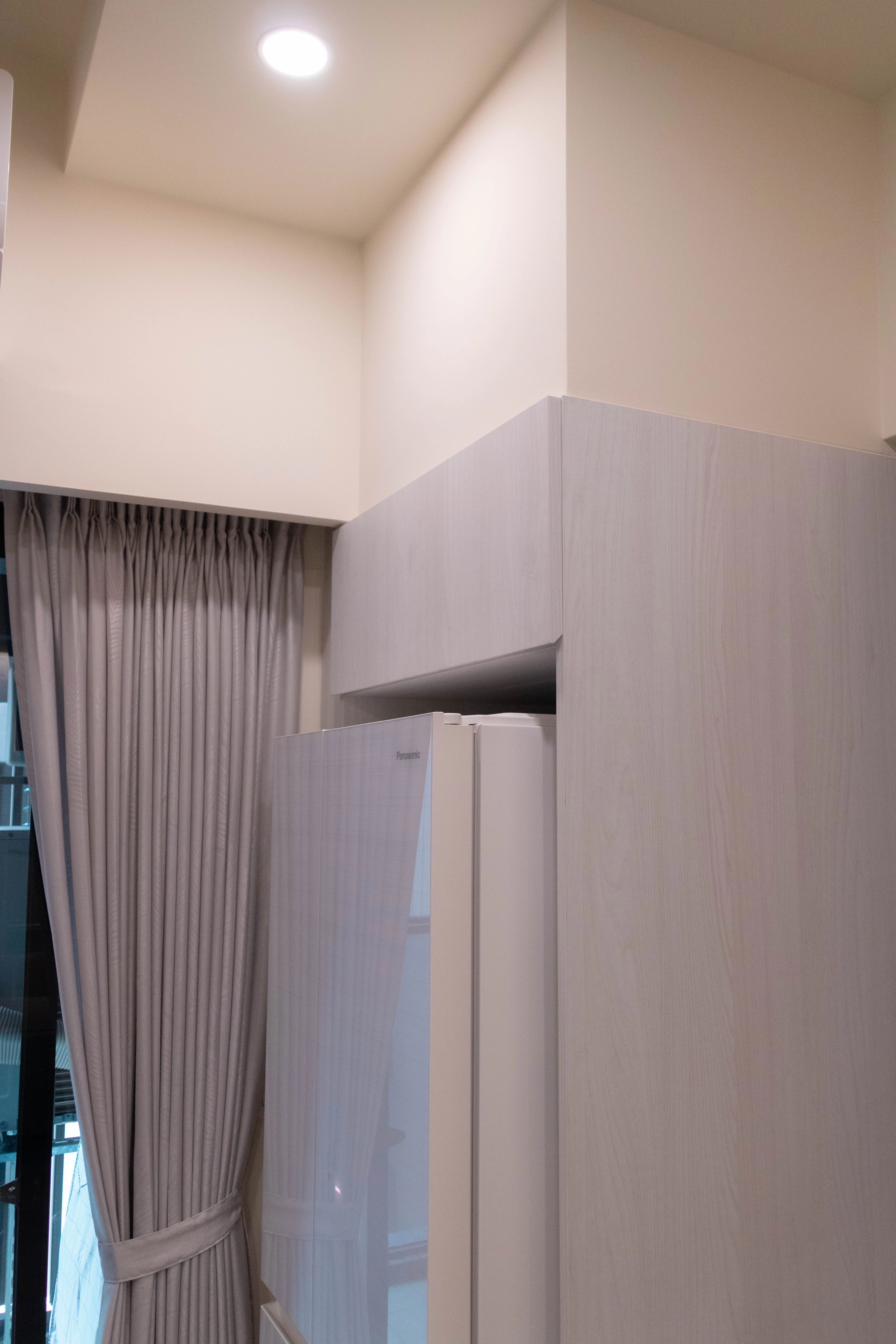 德盈室內設計：客製化冰箱櫃上方封頂櫃規劃，極大化廚房垂直收納空間，維持視覺清爽俐落的現代美學。