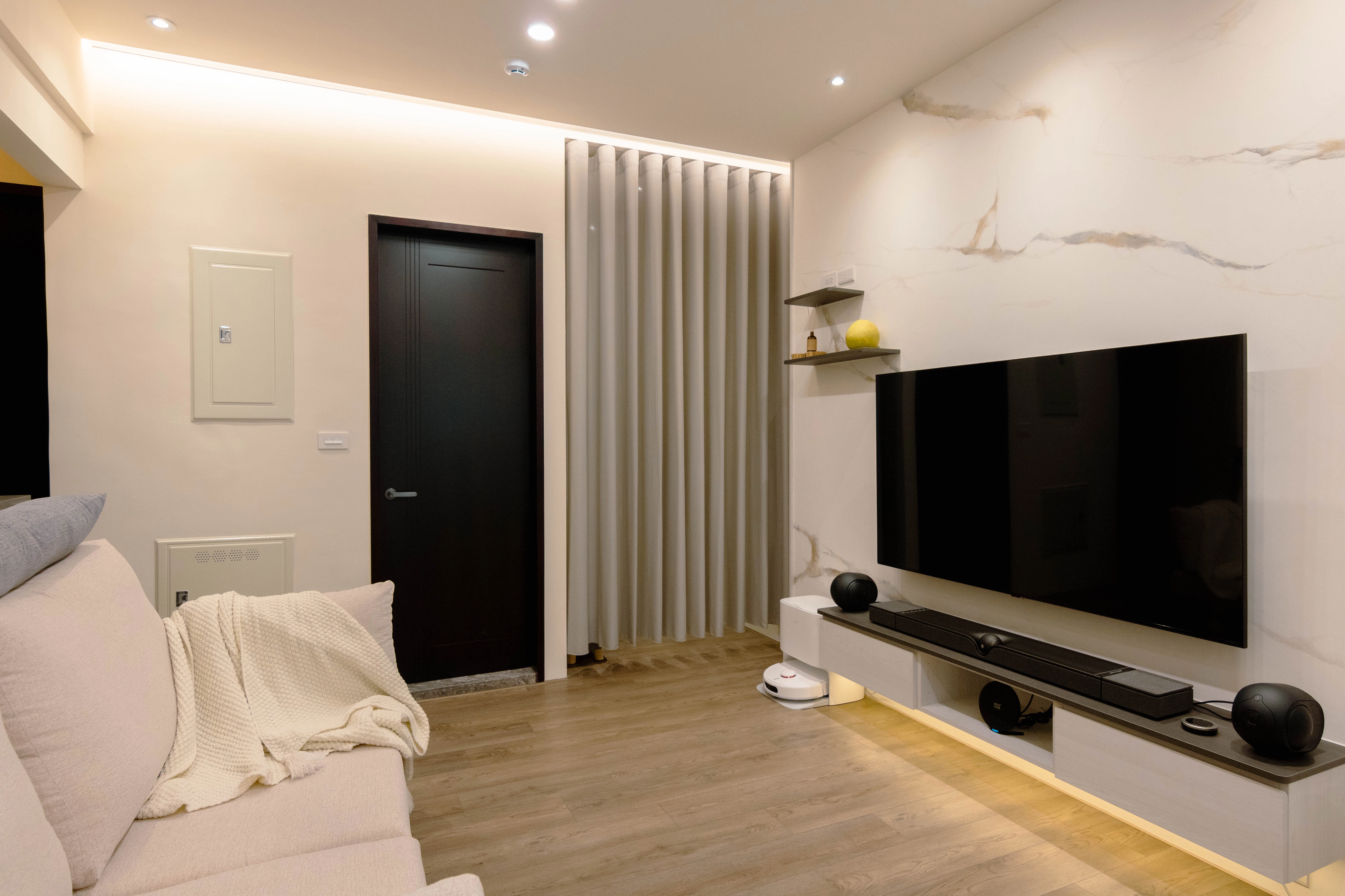 德盈客廳裝修：整合掃地機器人收納與藝術層板，打造高機能現代生活空間。