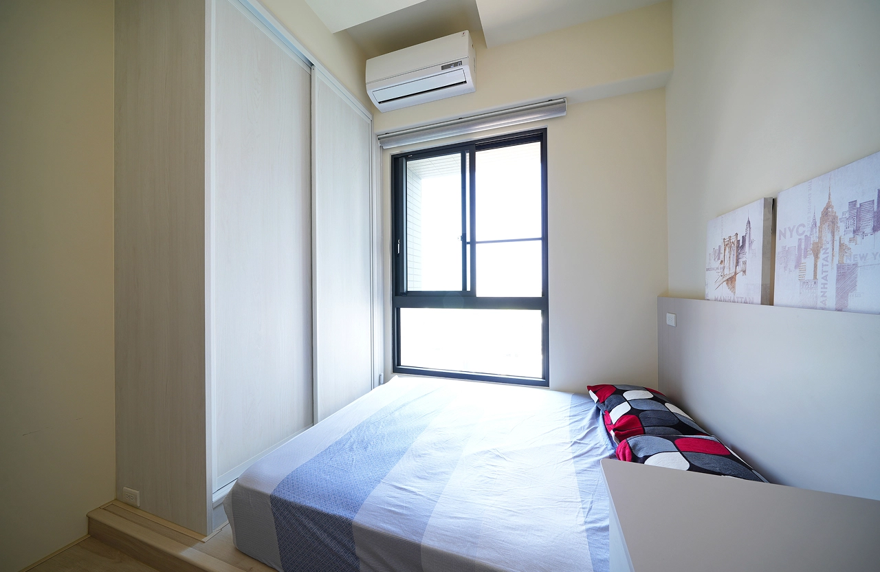 德盈設計客房配置：利用架高式地台增加儲物機能，結合不佔走道的系統衣櫃推拉門設計，放大臥室使用空間。