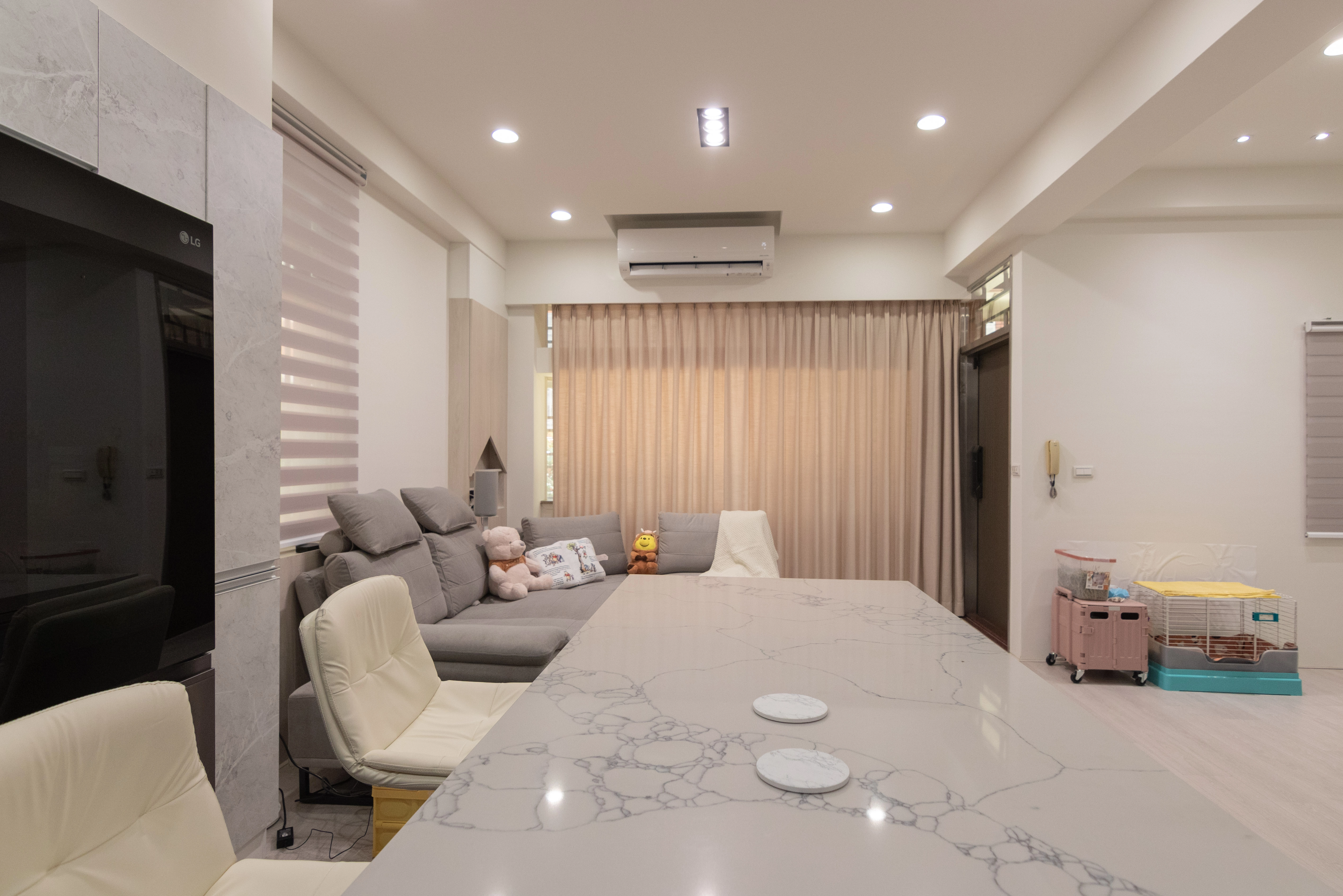 老屋翻修客廳規劃:開放式中島餐桌連接寬敞客廳,搭配柔和落地窗簾採光,重塑中古屋明亮生活動線。