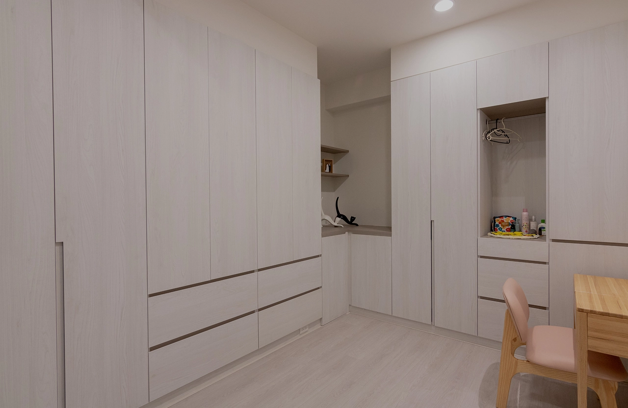 臥室系統家具規劃，白色系統衣櫃連結化妝桌與開放式層板，客製化設計完美滿足日常收納與美妝需求。