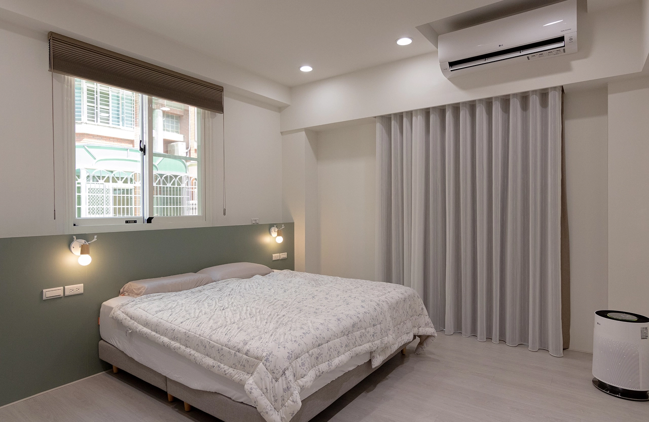 莫蘭迪綠系統床頭背牆搭配淺色木地板，營造簡約質感的臥室空間設計，提升居家睡眠氛圍。