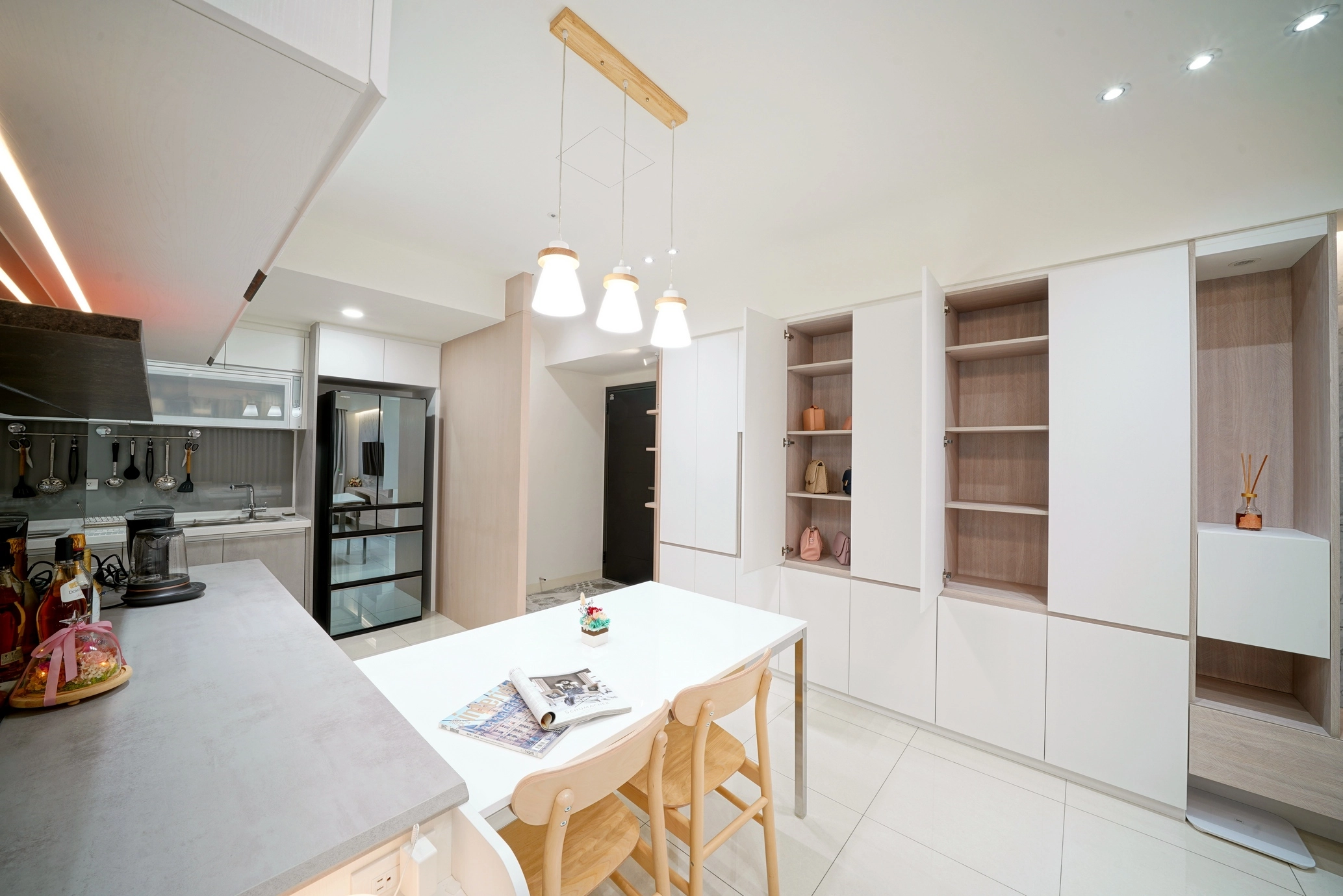 德盈設計餐廳實景:白色系統收納櫃延伸至牆面,搭配簡約吊燈,打造機能與美感兼具用餐區。