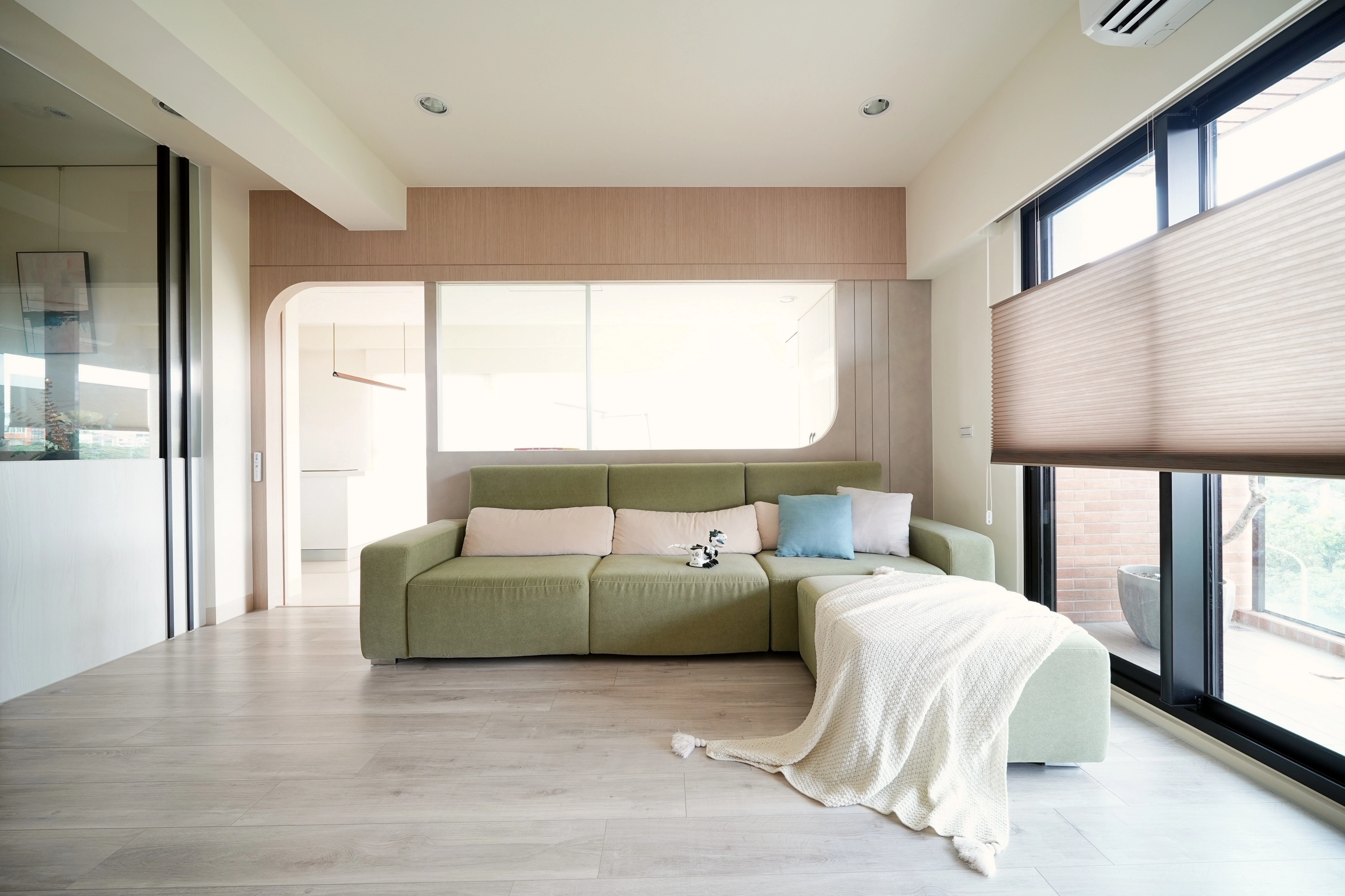 弧形木作隔間牆,搭配冰柱玻璃隔屏。柔和視線,巧妙劃分客廳與餐廳場域。