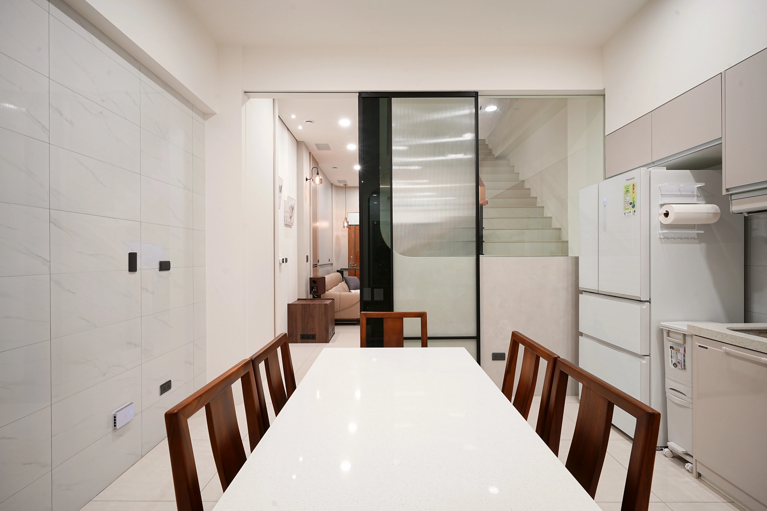 德盈設計:通透玻璃推拉門隔絕客廳與廚房油煙,維持開放式視覺感,落實清爽俐落的餐廚動線。