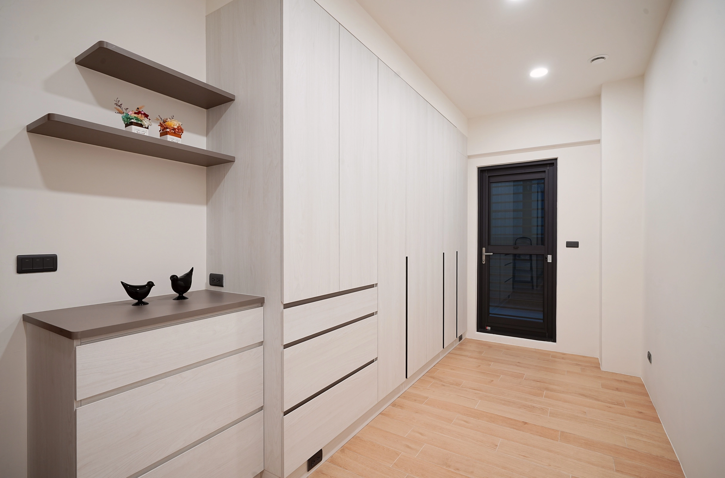 德盈室內設計:系統櫃選用柔和可可跳色,結合細緻木紋材質,營造出優雅且沈穩的現代居家收納風格。