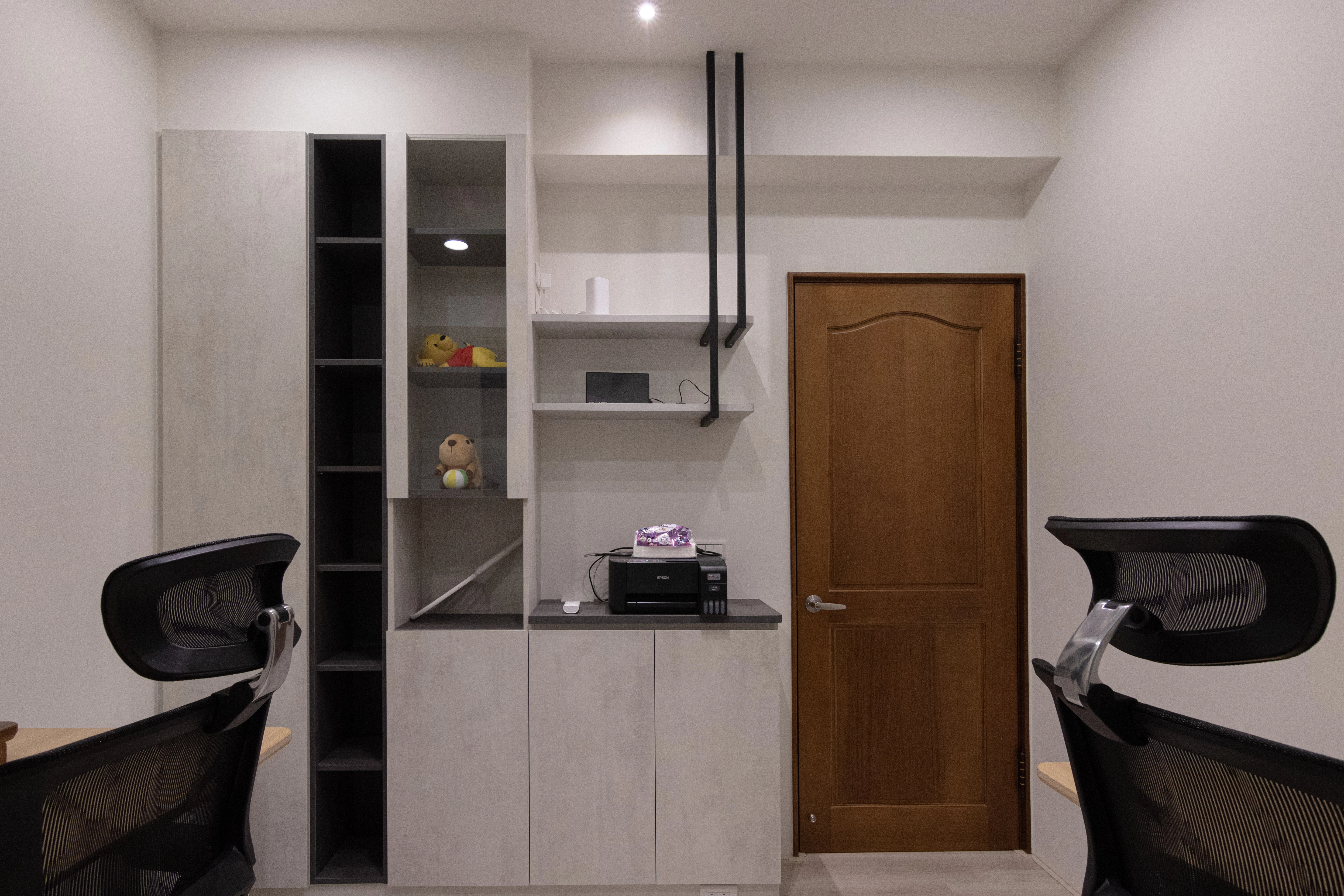 簡約風書房設計採用開放式系統書櫃,搭配黑色造型鐵件吊架與系統桌面,打造具現代感的居家辦公與收納空間。