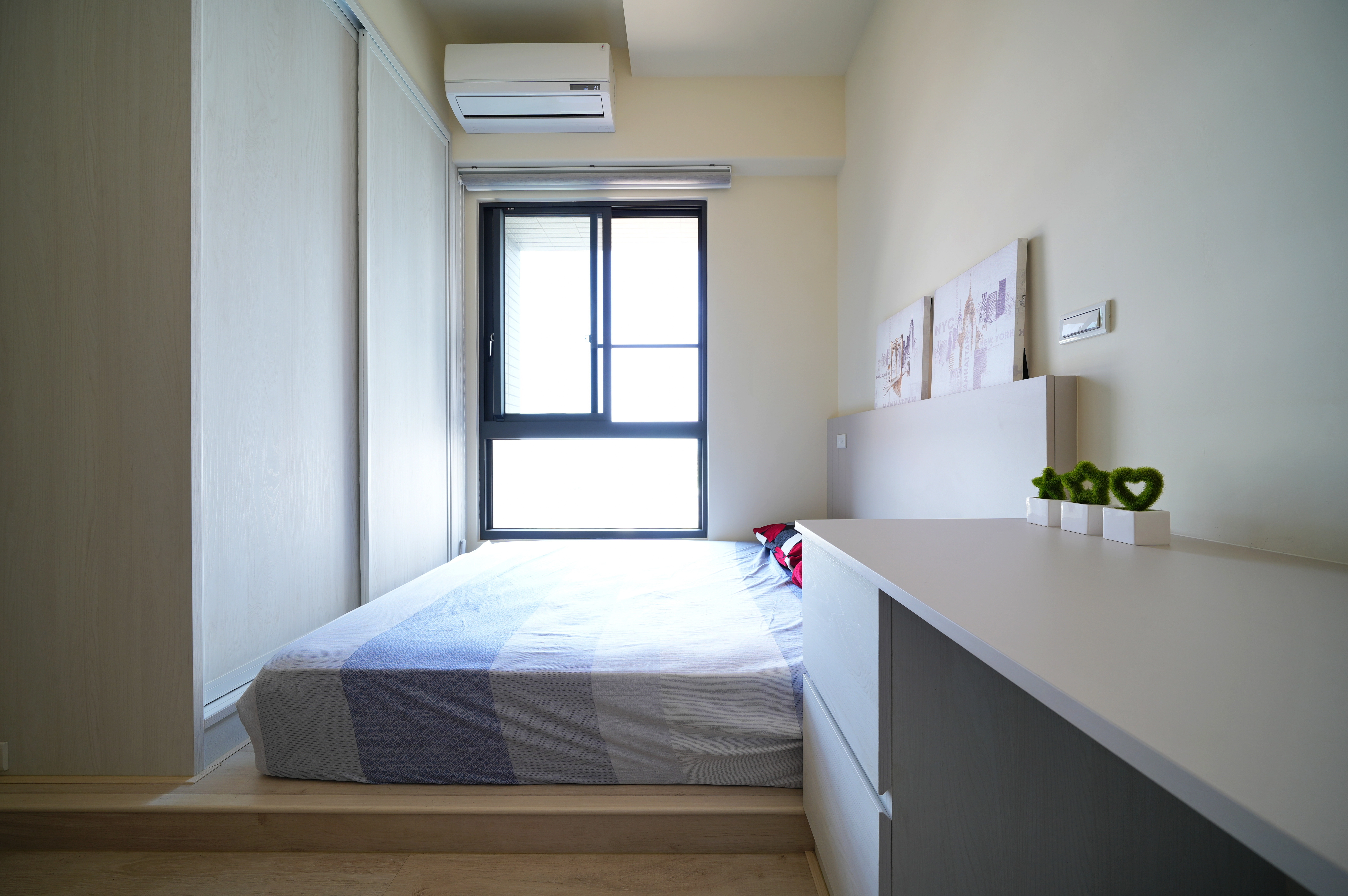 德盈室內設計客房裝修:推拉門系統衣櫃節省走道空間,搭配舒適架高式地台,創造小坪數極致收納與機能美感。