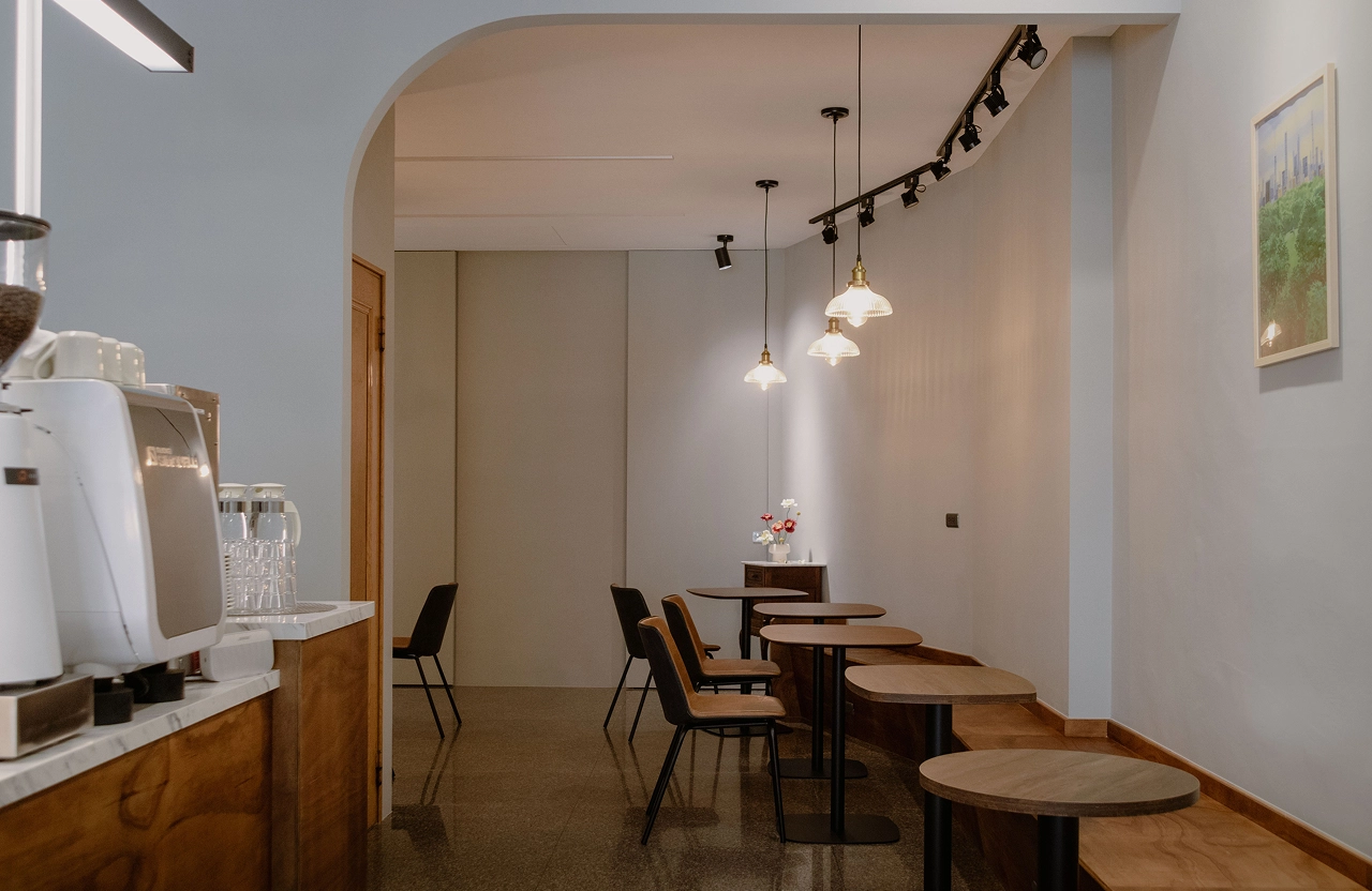 木作靠窗與靠牆椅，鐵件鋁框內崁長虹玻璃屏風，界定座位區並增添隱密性。