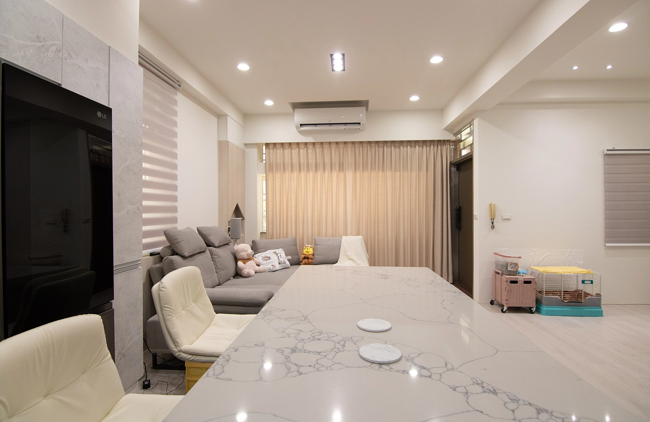 老屋翻修客廳規劃：開放式中島餐桌連接寬敞客廳，搭配柔和落地窗簾採光，重塑中古屋明亮生活動線。