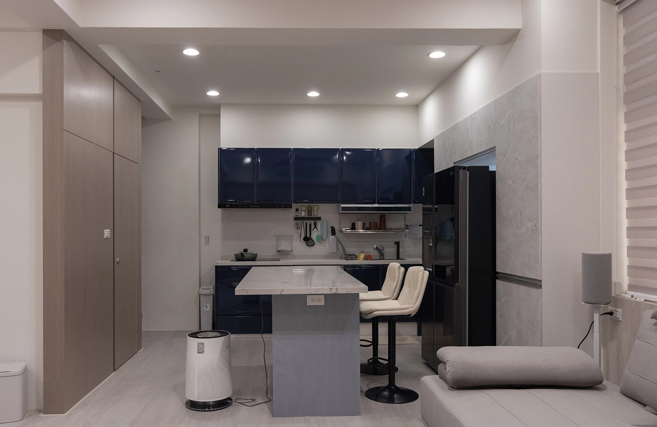 中古屋翻修案例：德盈室內設計打造開放式廚房，深藍色廚具搭配石紋中島與系統櫃，翻新居家動線。