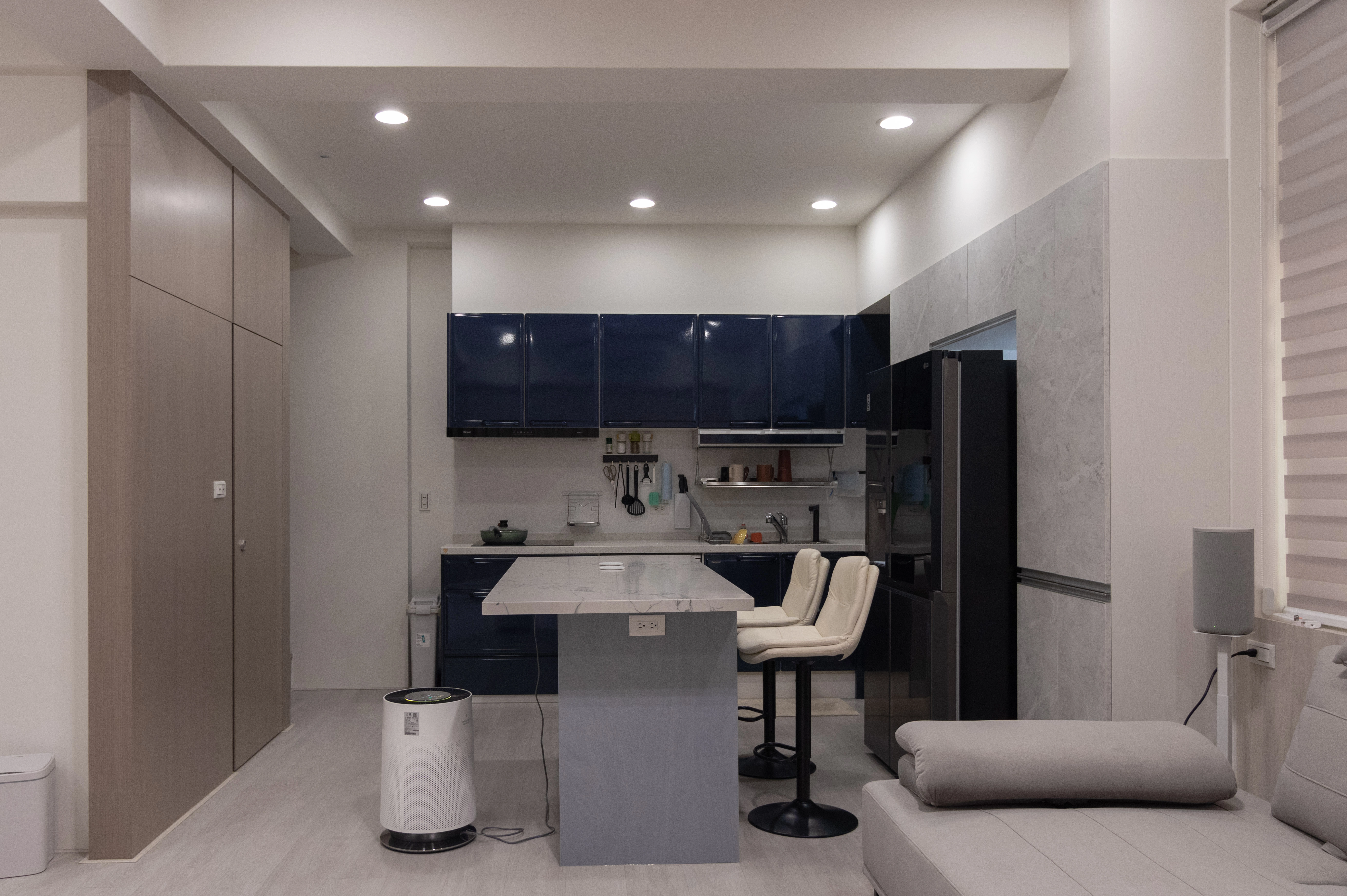 中古屋翻修案例:德盈室內設計打造開放式廚房,深藍色廚具搭配石紋中島與系統櫃,翻新居家動線。