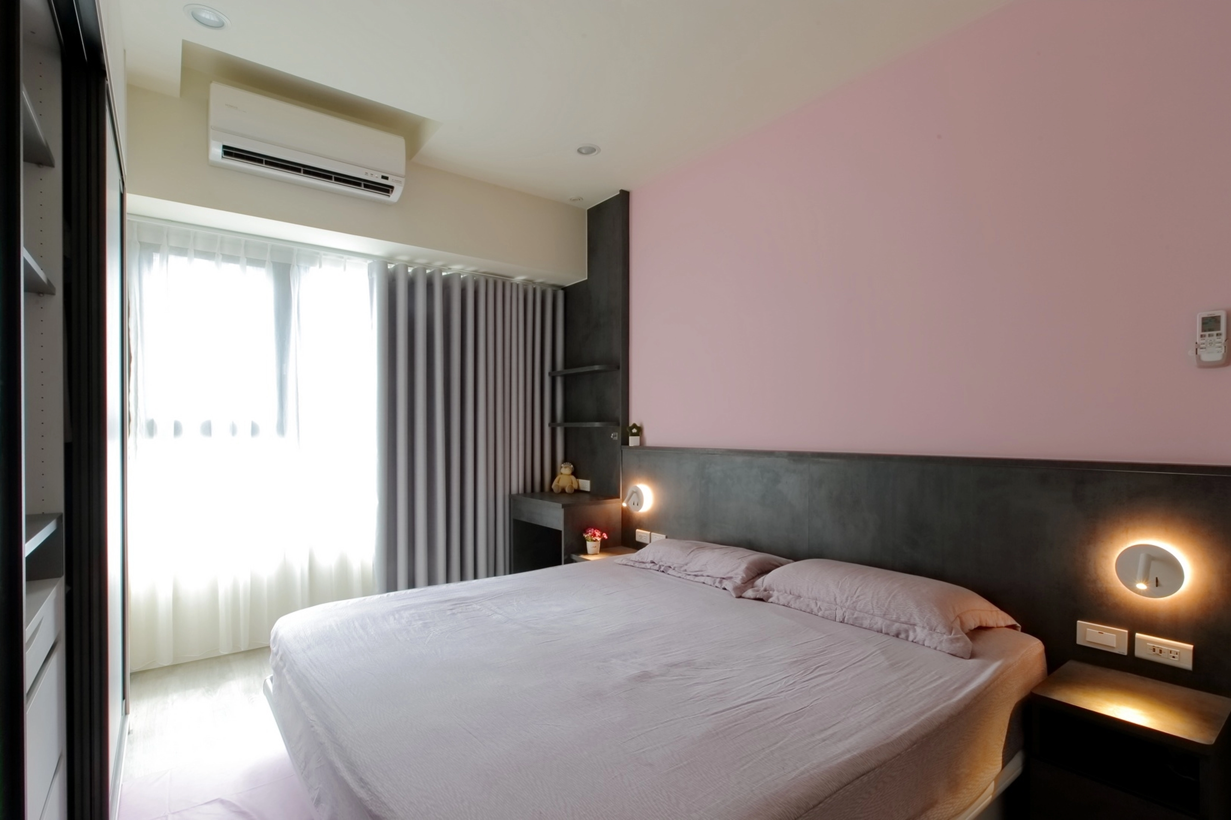 德盈設計臥室實景:粉色床頭牆搭配深色軟墊背板,營造溫潤柔和睡眠氛圍。