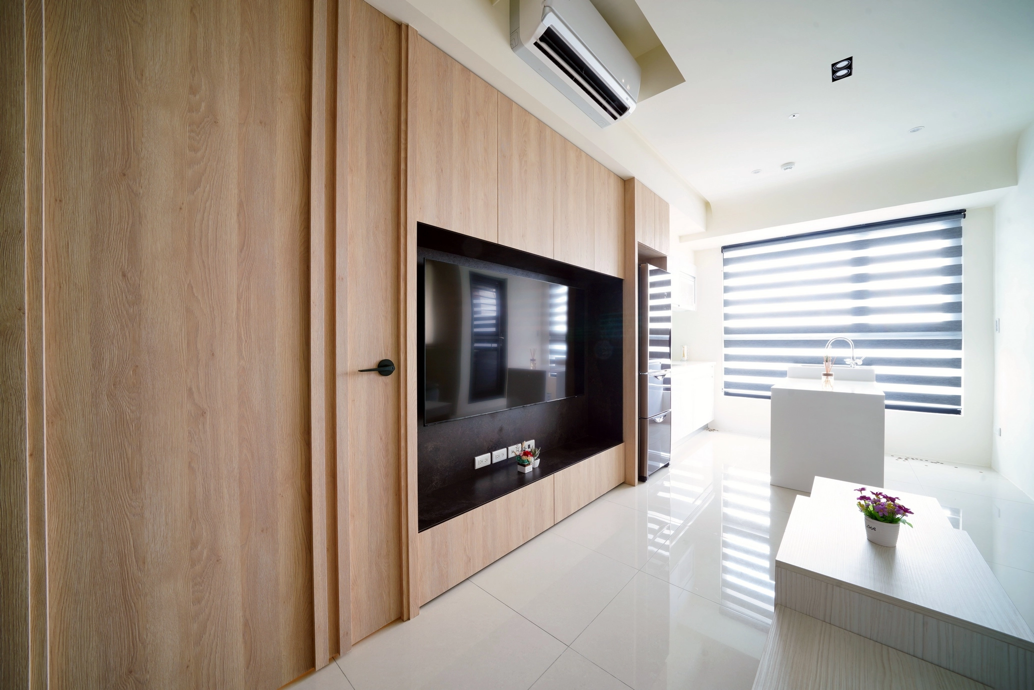 14坪北歐風新成屋。木質與白色調客廳,電視牆結合收納,營造溫馨俐落氛圍。