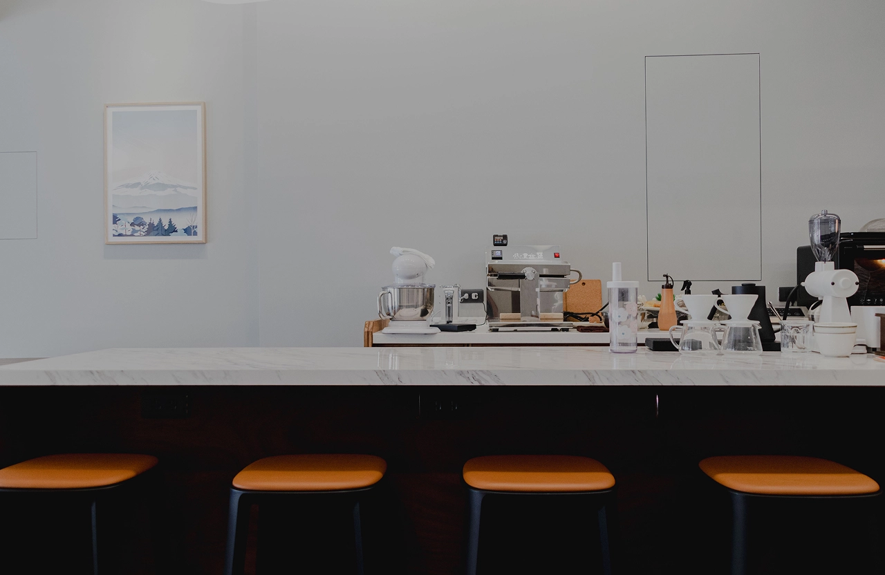 德盈室內設計商業空間：選用耐磨質感人造石吧檯，提升咖啡廳作業效率並營造極簡現代美學。